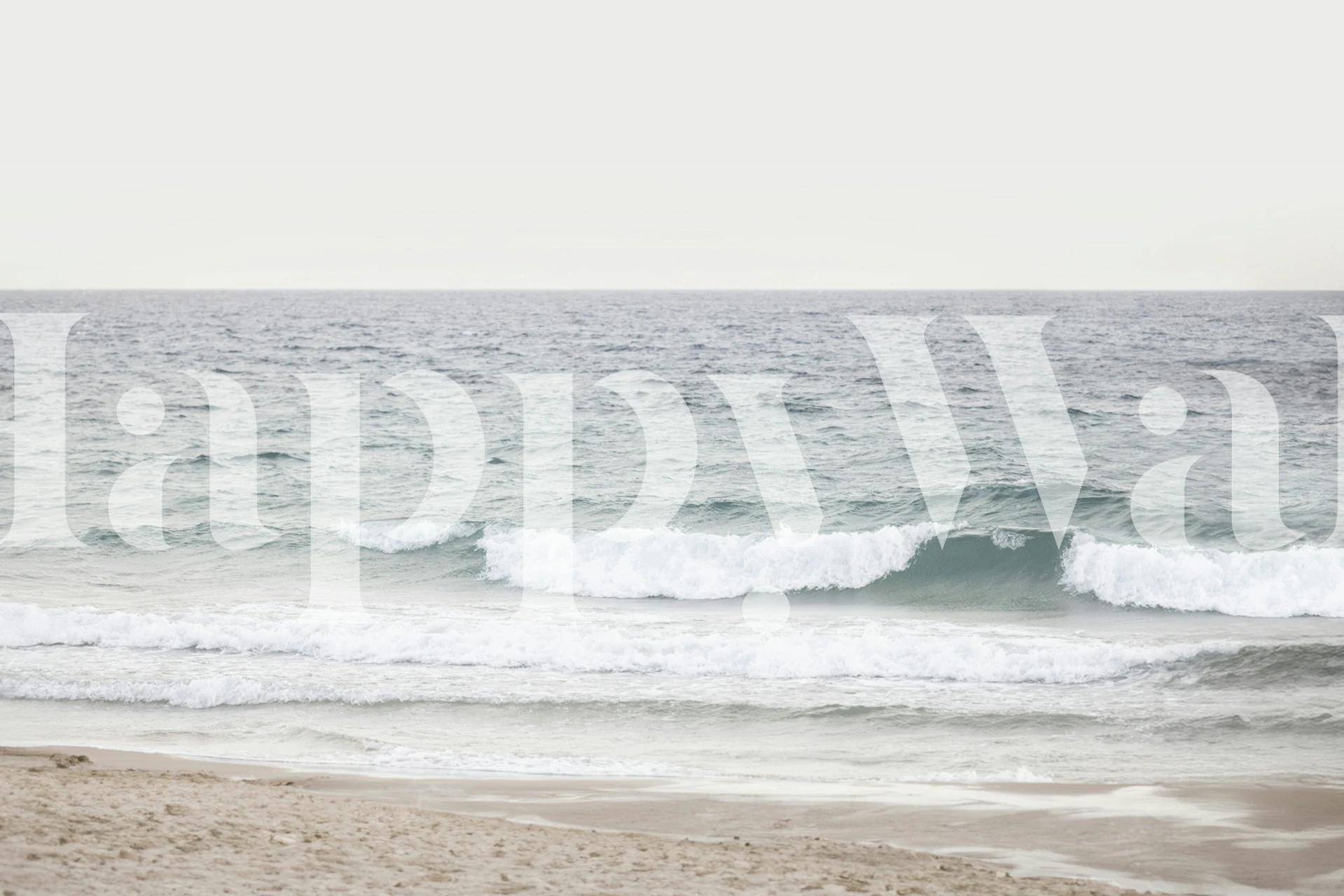 Ocean waves on a beach with soft beige sand and blue water wallpaper