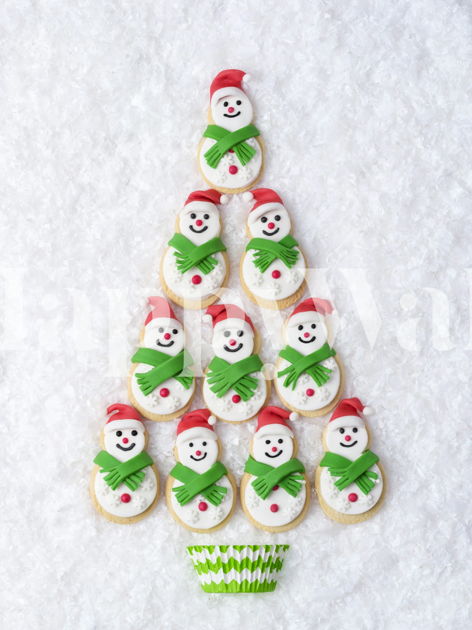 Snowman cookies decorated with red hats and green scarves on white background wallpaper