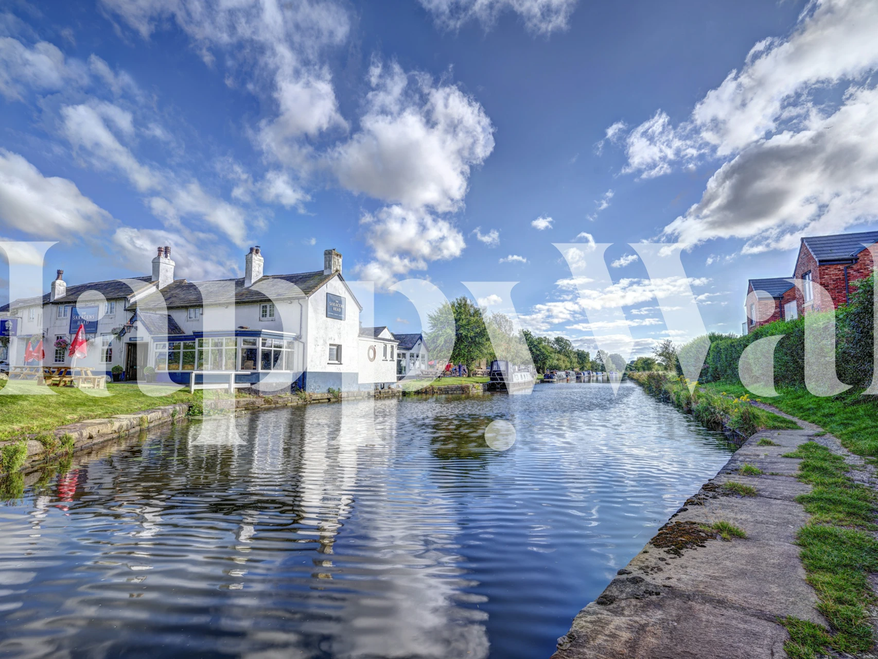 Canalside scenery with blue sky, green trees, and reflections wallpaper