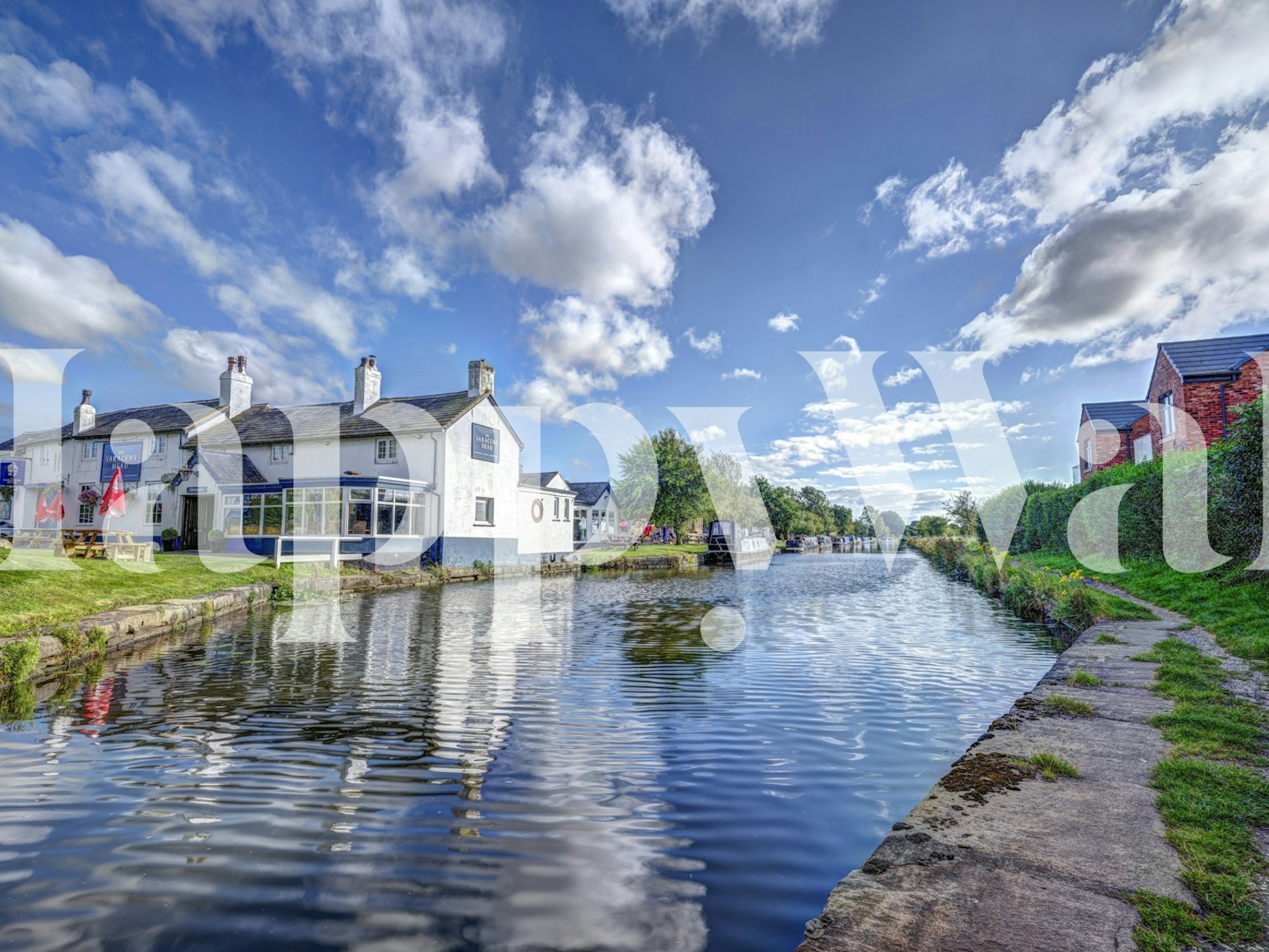 Canalside scenery with blue sky, green trees, and reflections wallpaper