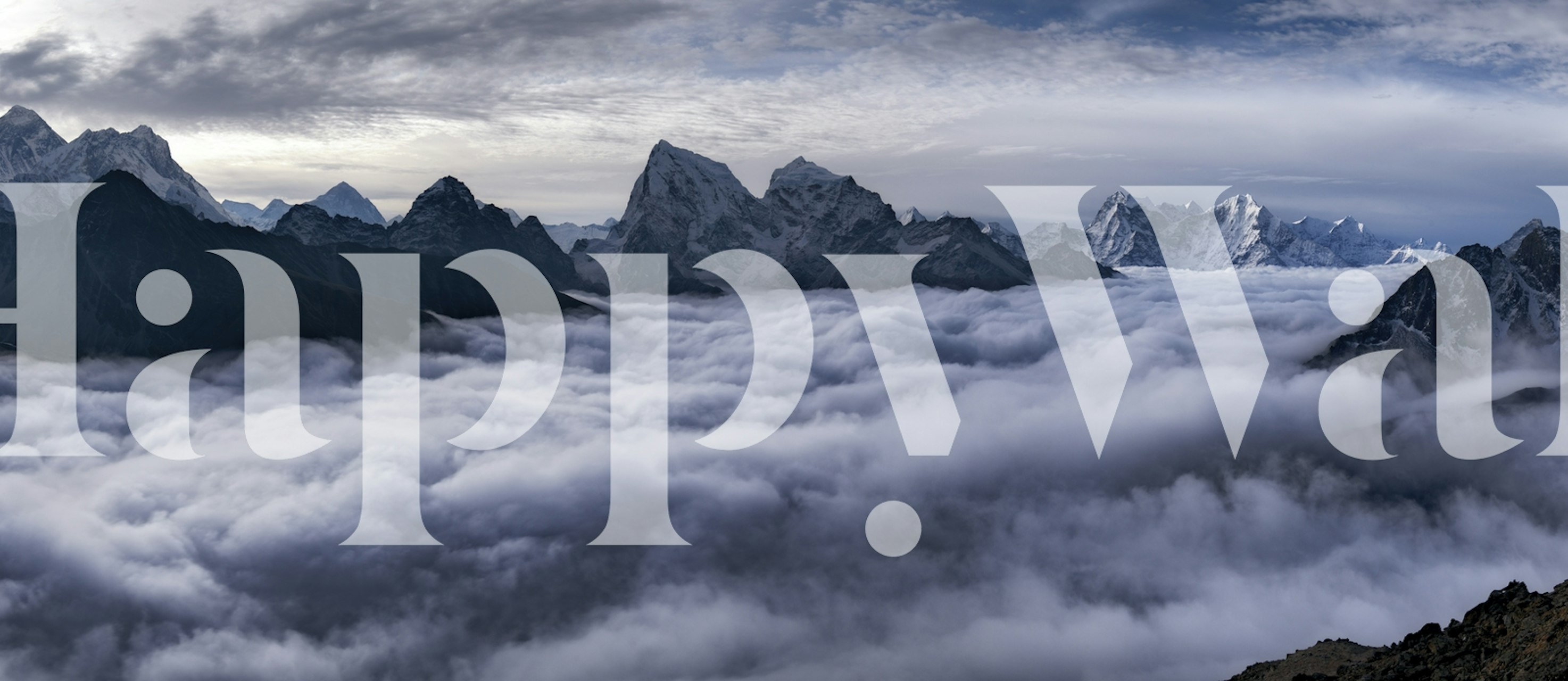 Mountain peaks surrounded by clouds wallpaper