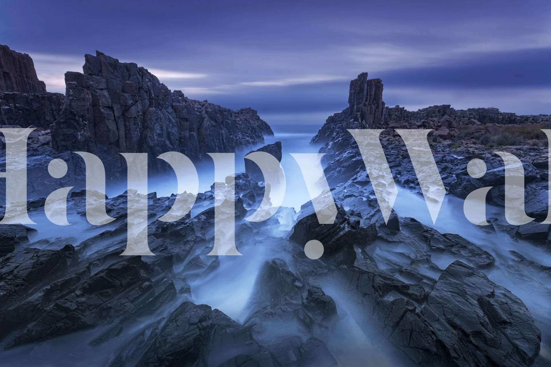 Rocky coastline with flowing water in blue tones wallpaper