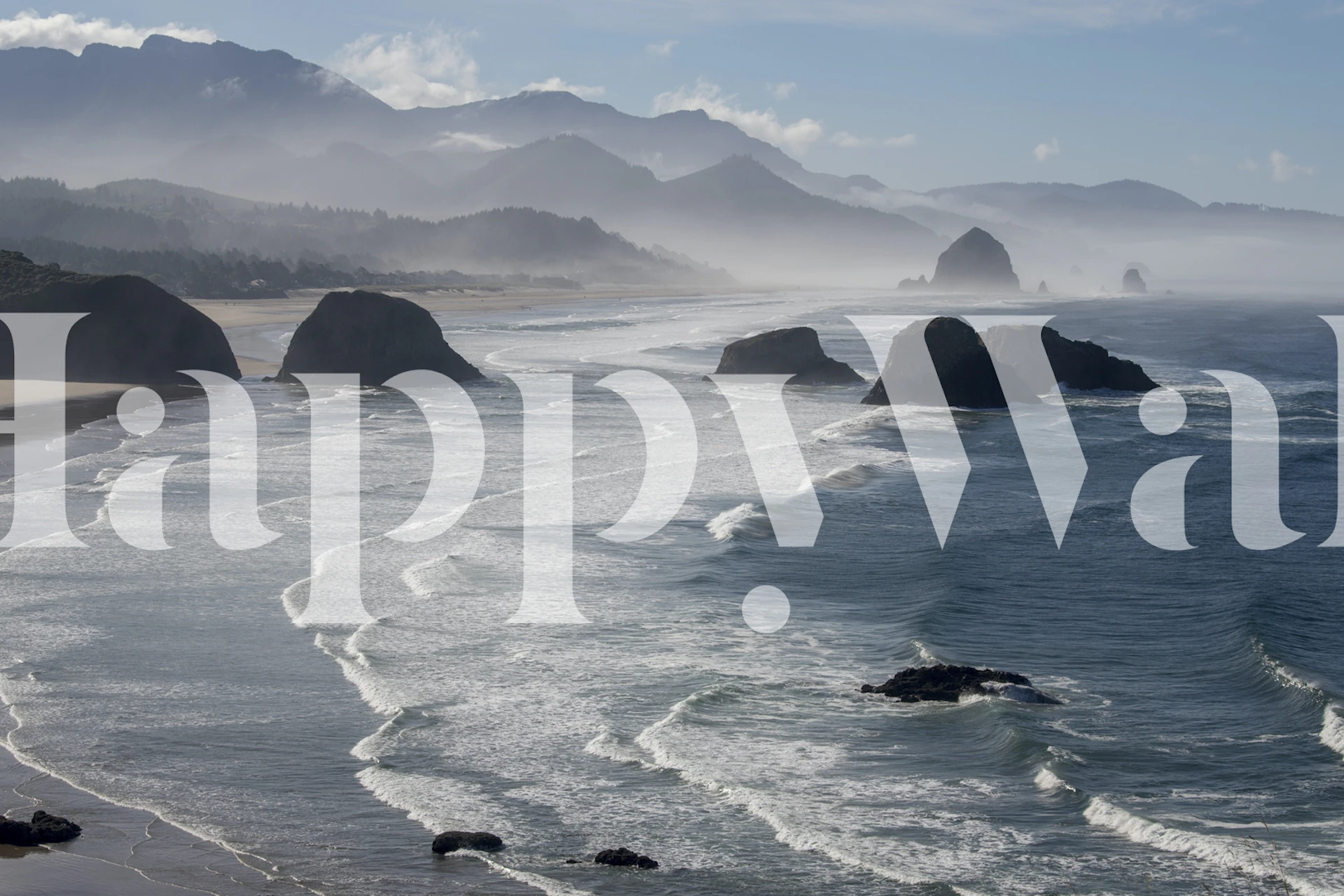 Ocean waves crashing on rocks under a misty sky wallpaper