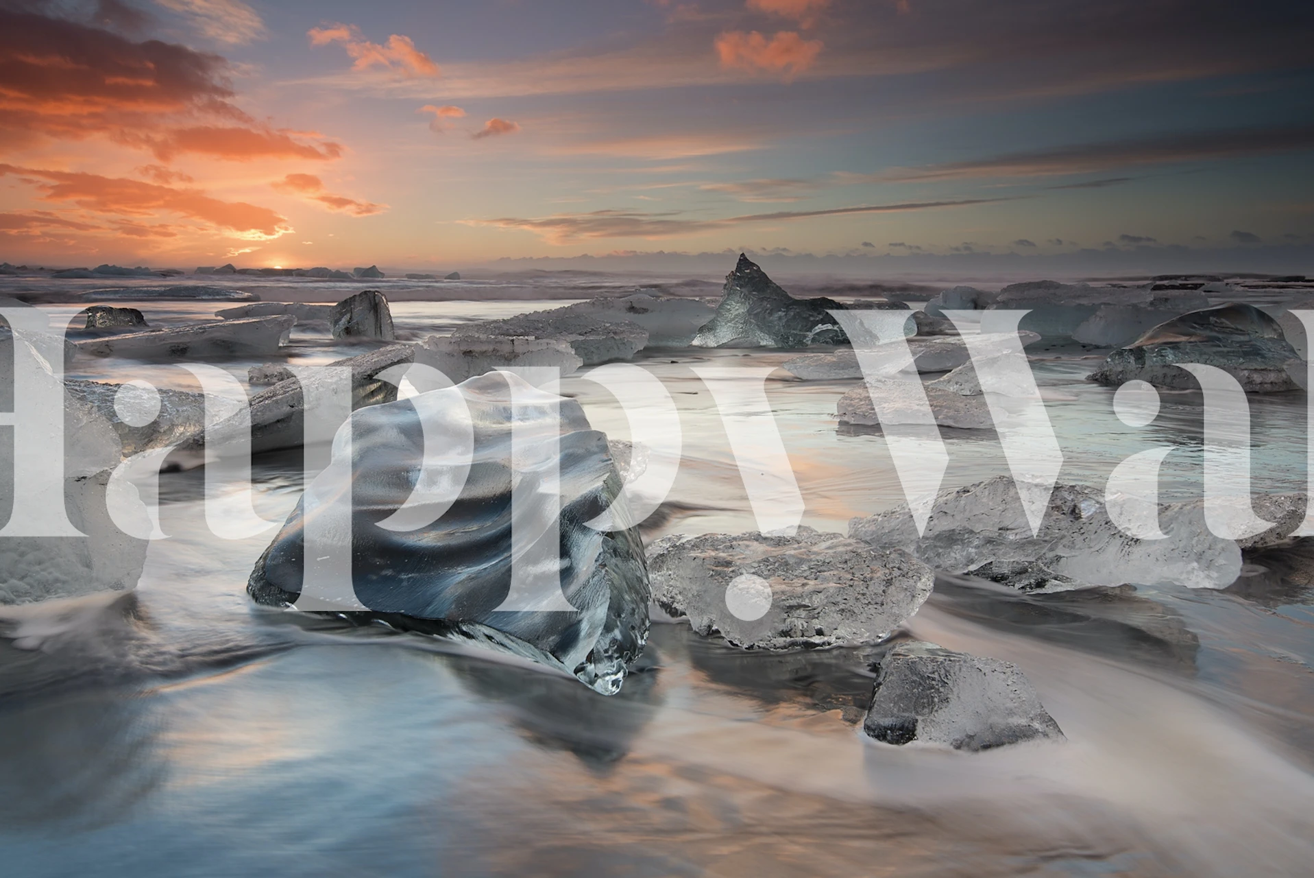 Icebergs on a beach at sunset with warm and cool tones wallpaper