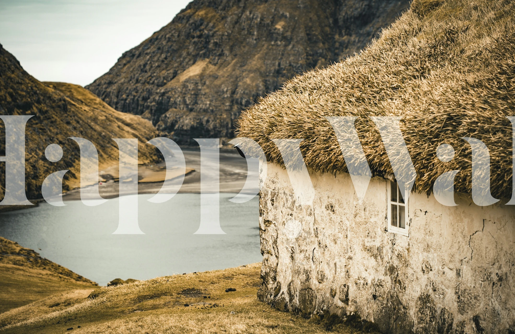 Rustic cottage on a lakeside with stone walls and grass roof wallpaper