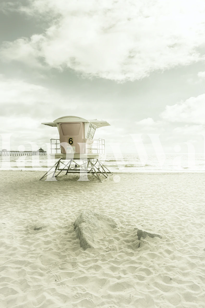 Vintage plavčíková věž na klidné písečné pláži se zataženou oblohou, která dodává poklidnou atmosféru kalifornského pobřeží.