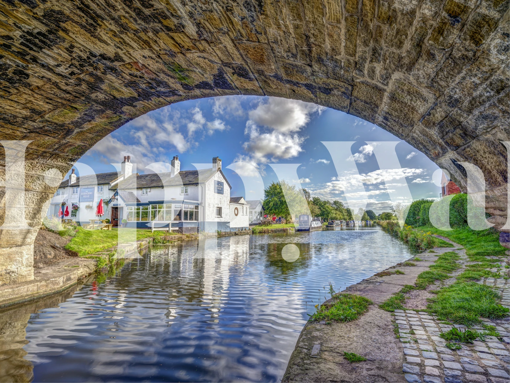 Canalside view with blue sky and greenery wallpaper