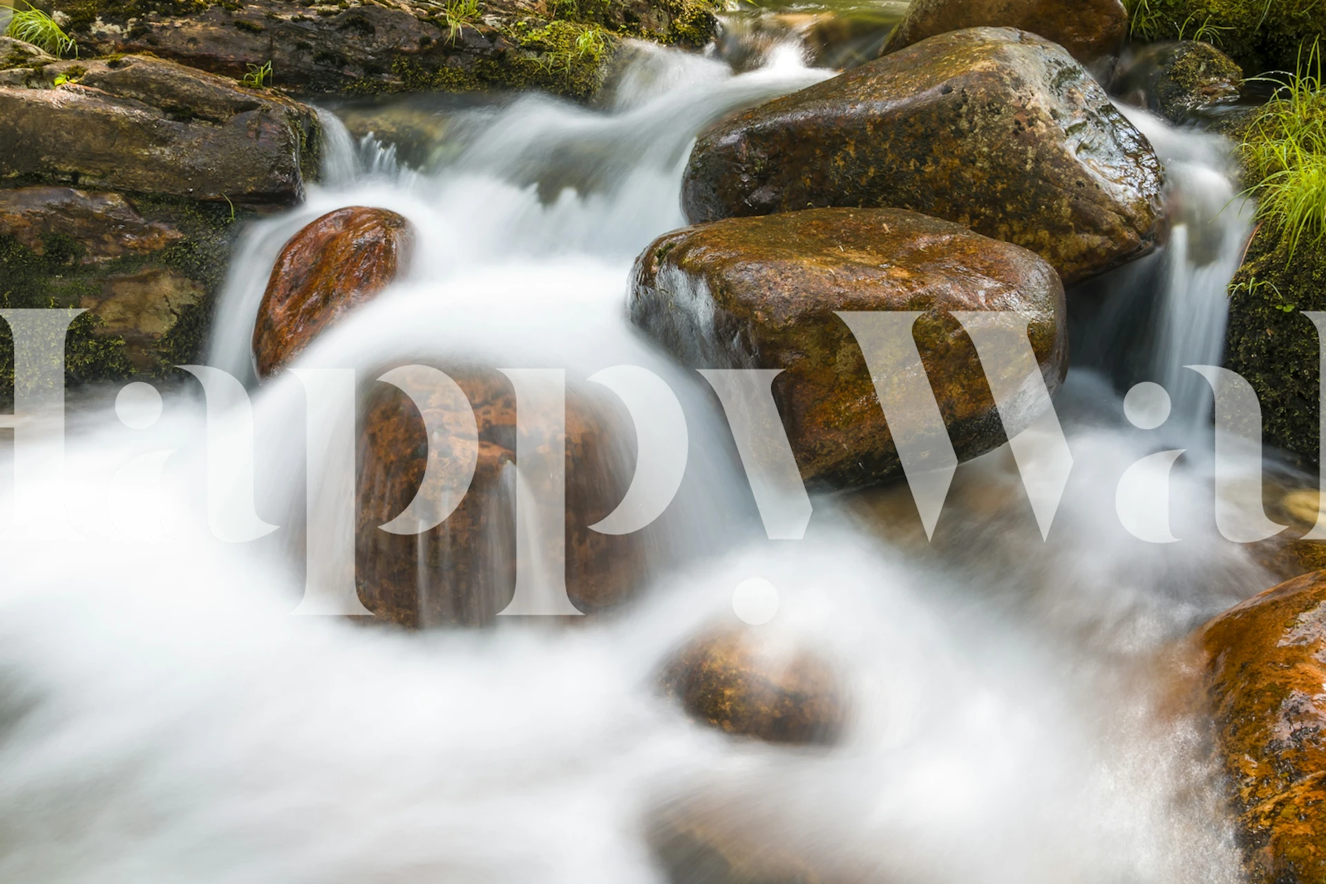 Flowing water over smooth amber rocks in a natural setting wallpaper