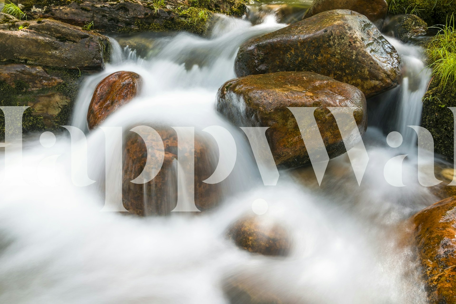 Flowing water over smooth amber rocks in a natural setting wallpaper