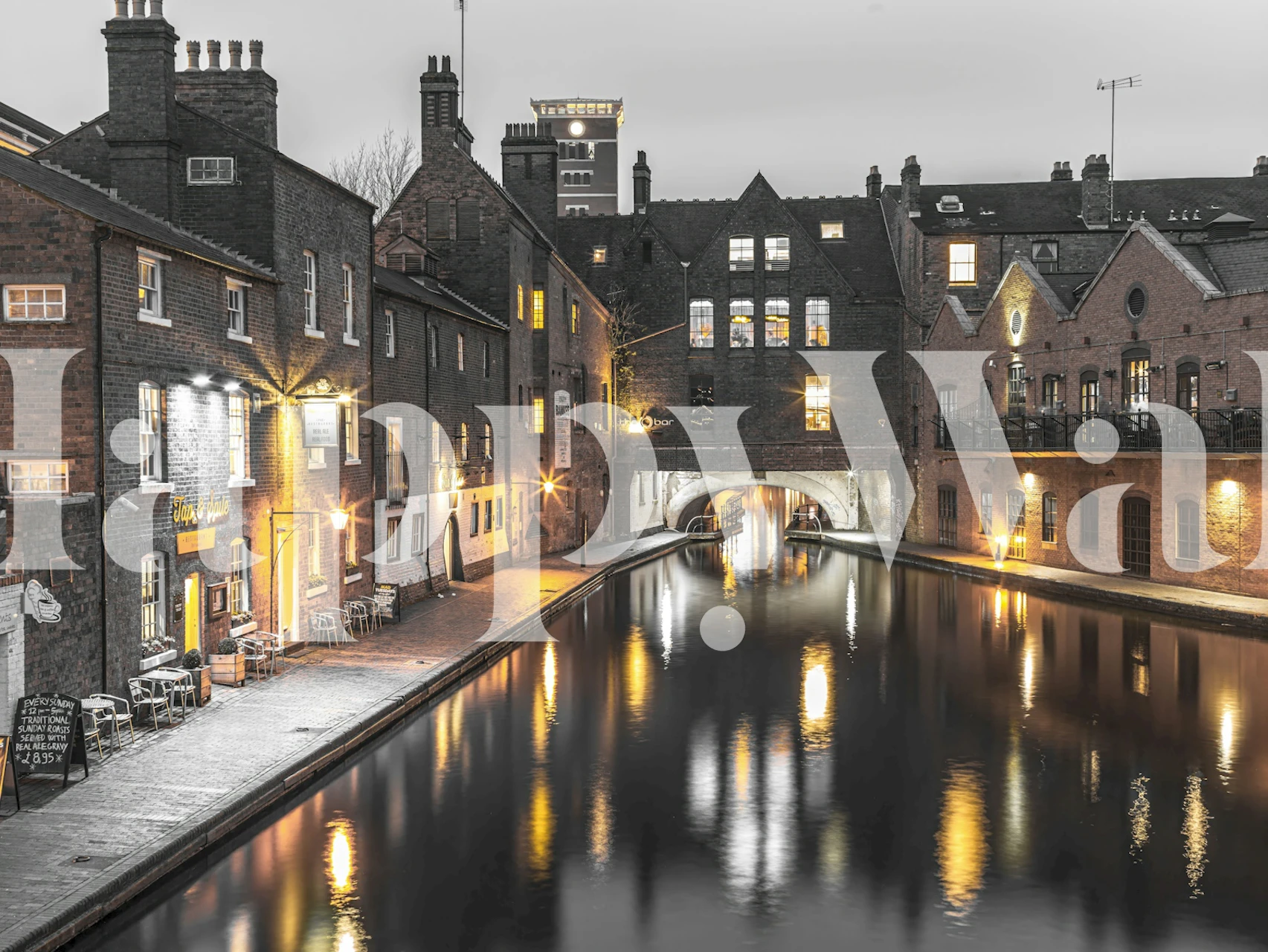 Black and white wallpaper with a canal scene and illuminated buildings