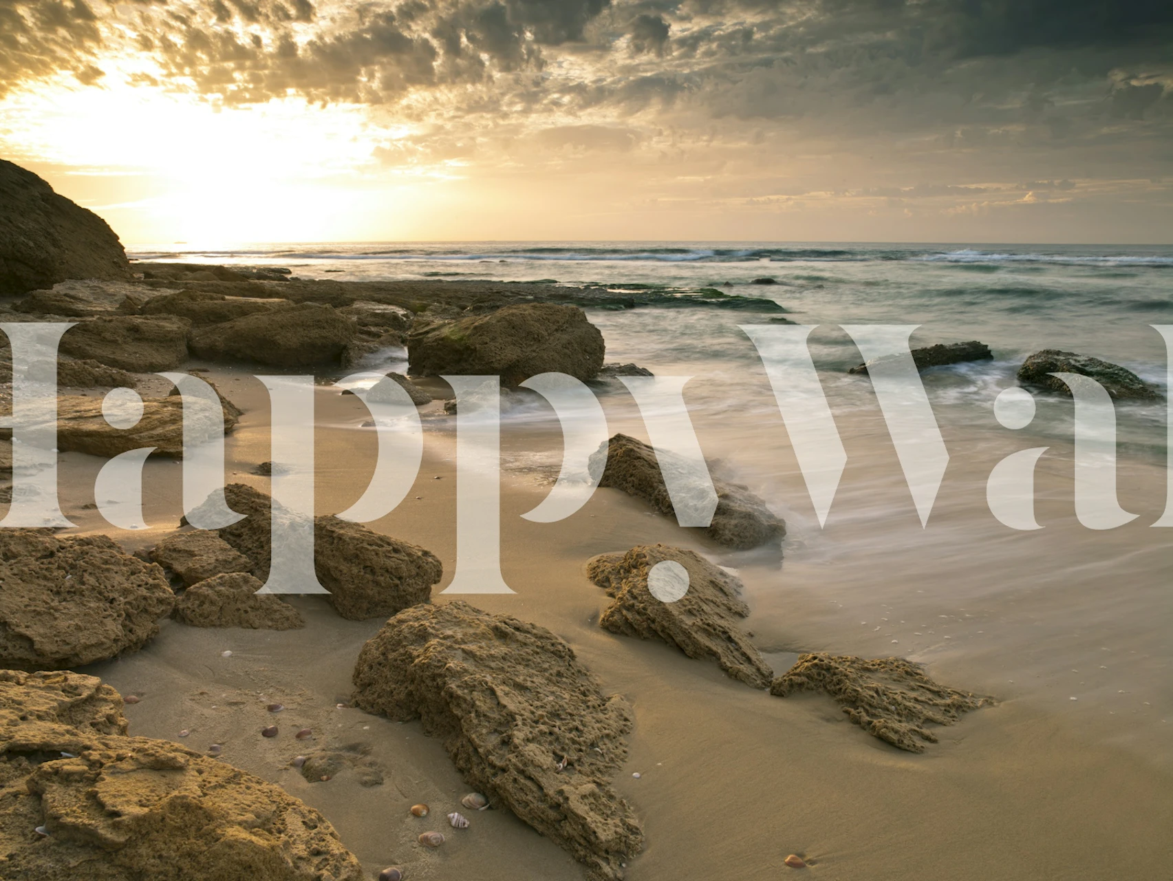 Sandy beach with rocky shores and ocean waves wallpaper