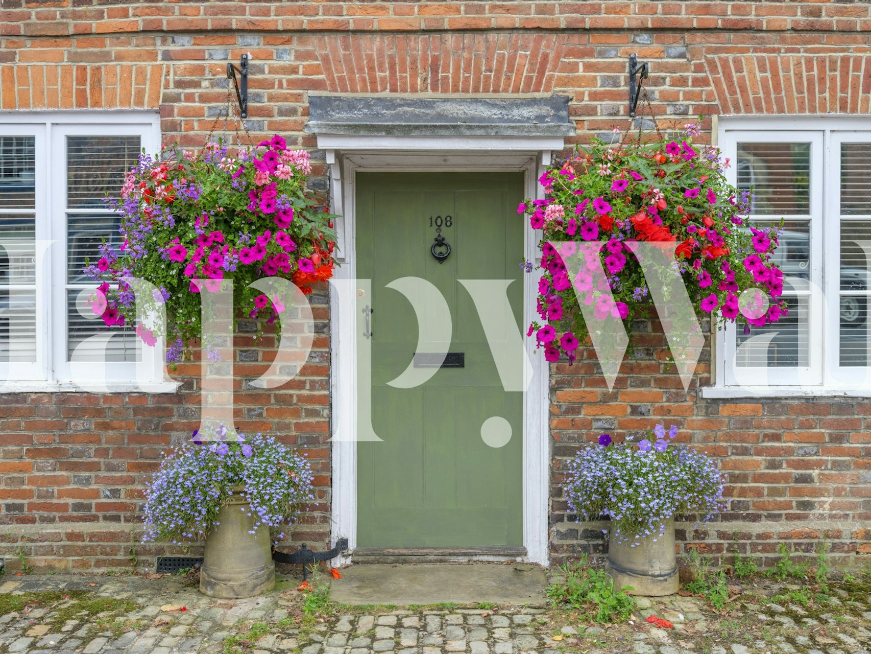 Floral wallpaper featuring a green door, vibrant flowers, and brick walls