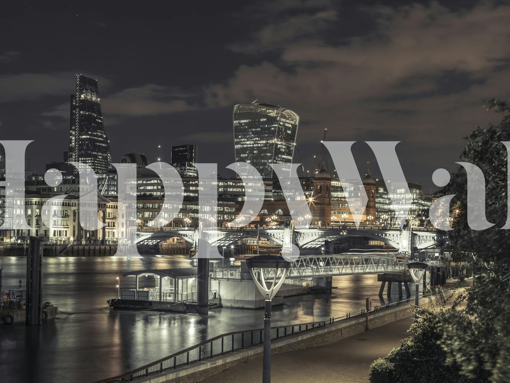 Nighttime cityscape with illuminated buildings and water reflections wallpaper