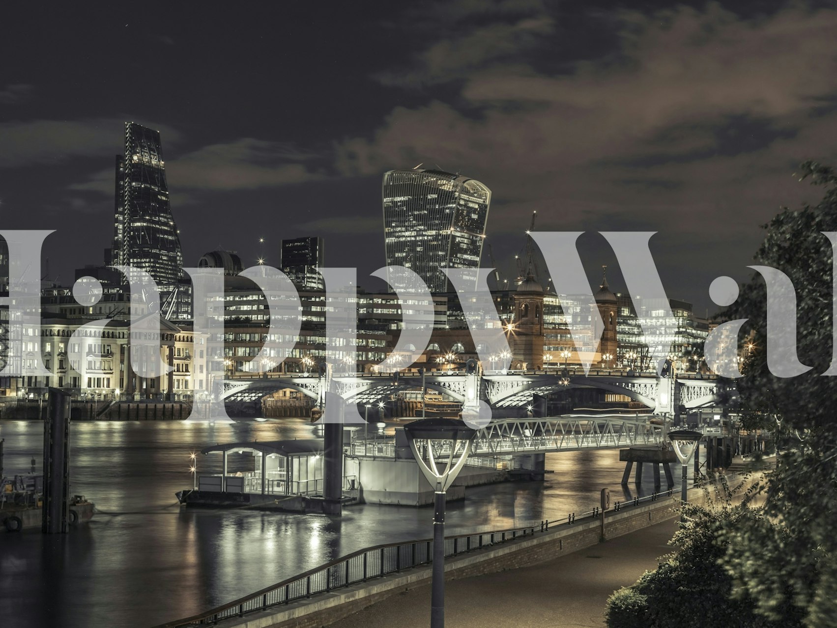 Nighttime cityscape with illuminated buildings and water reflections wallpaper