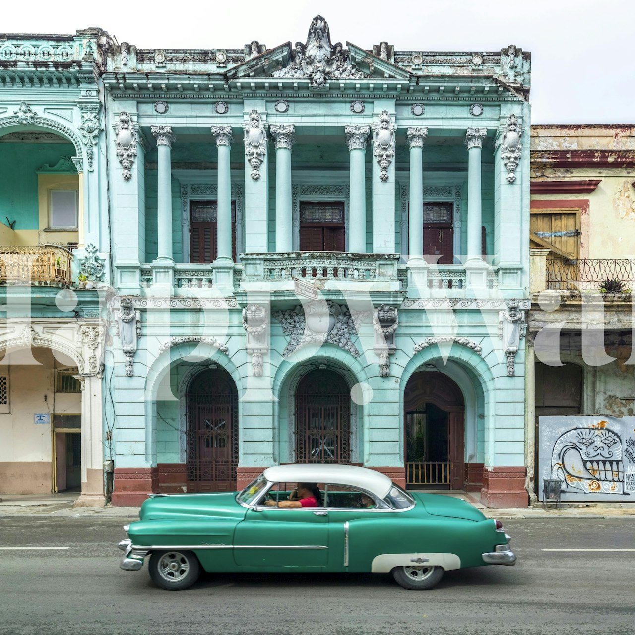 Classic car against turquoise historical facade wallpaper