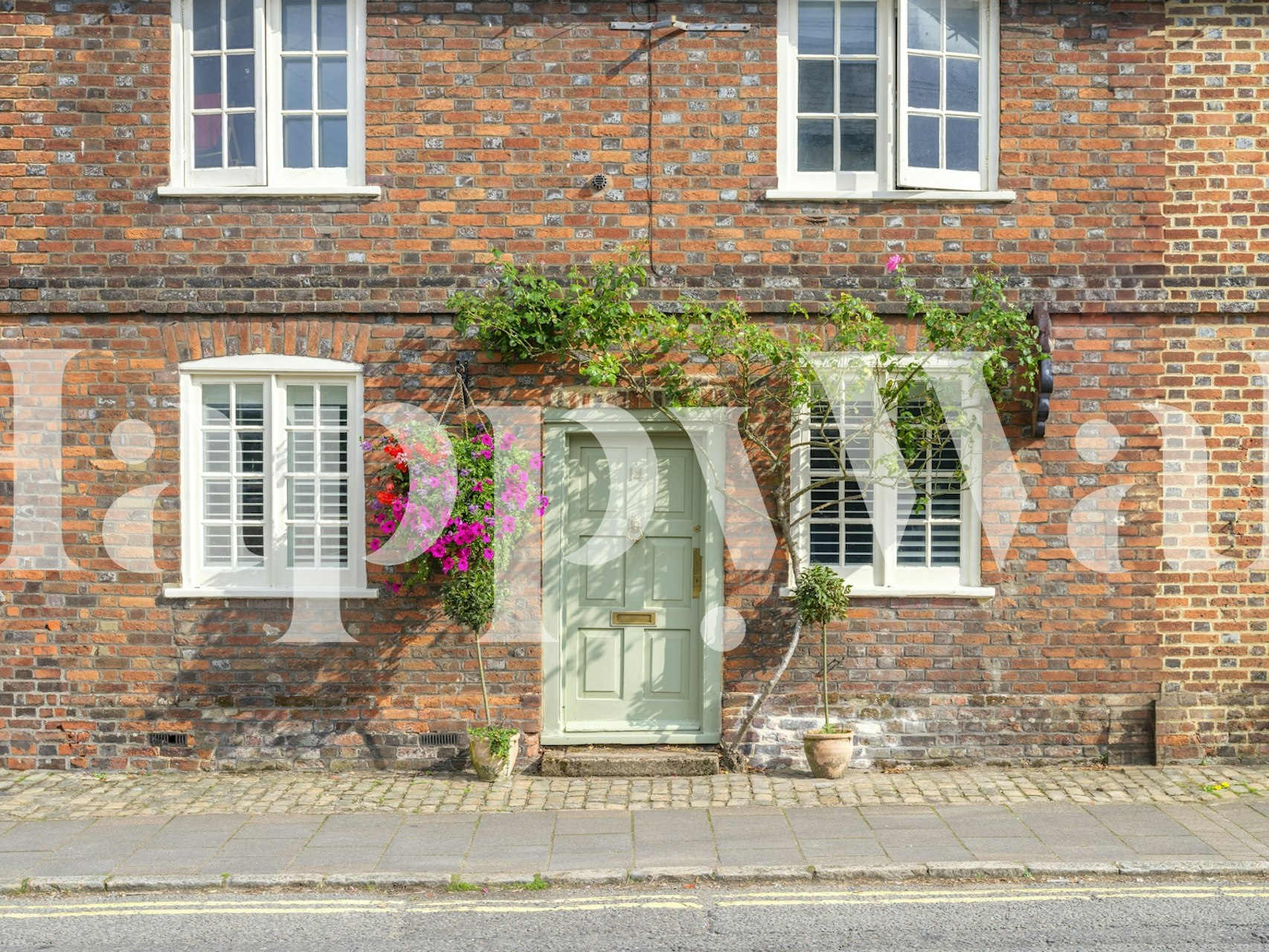 Cottage exterior with brick wall, green door, and flowers wallpaper