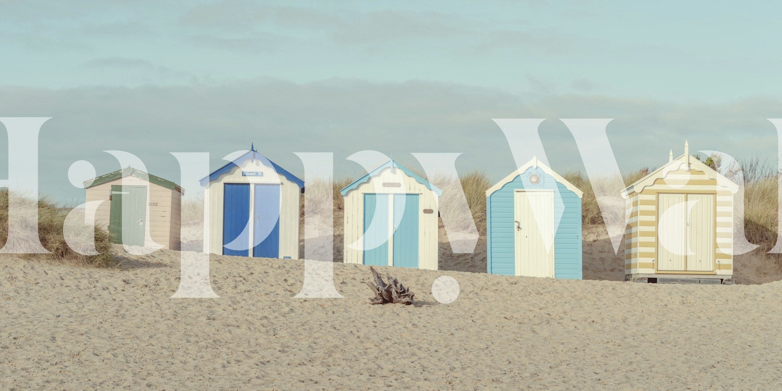 Colorful beach huts in soft sandy surroundings wallpaper