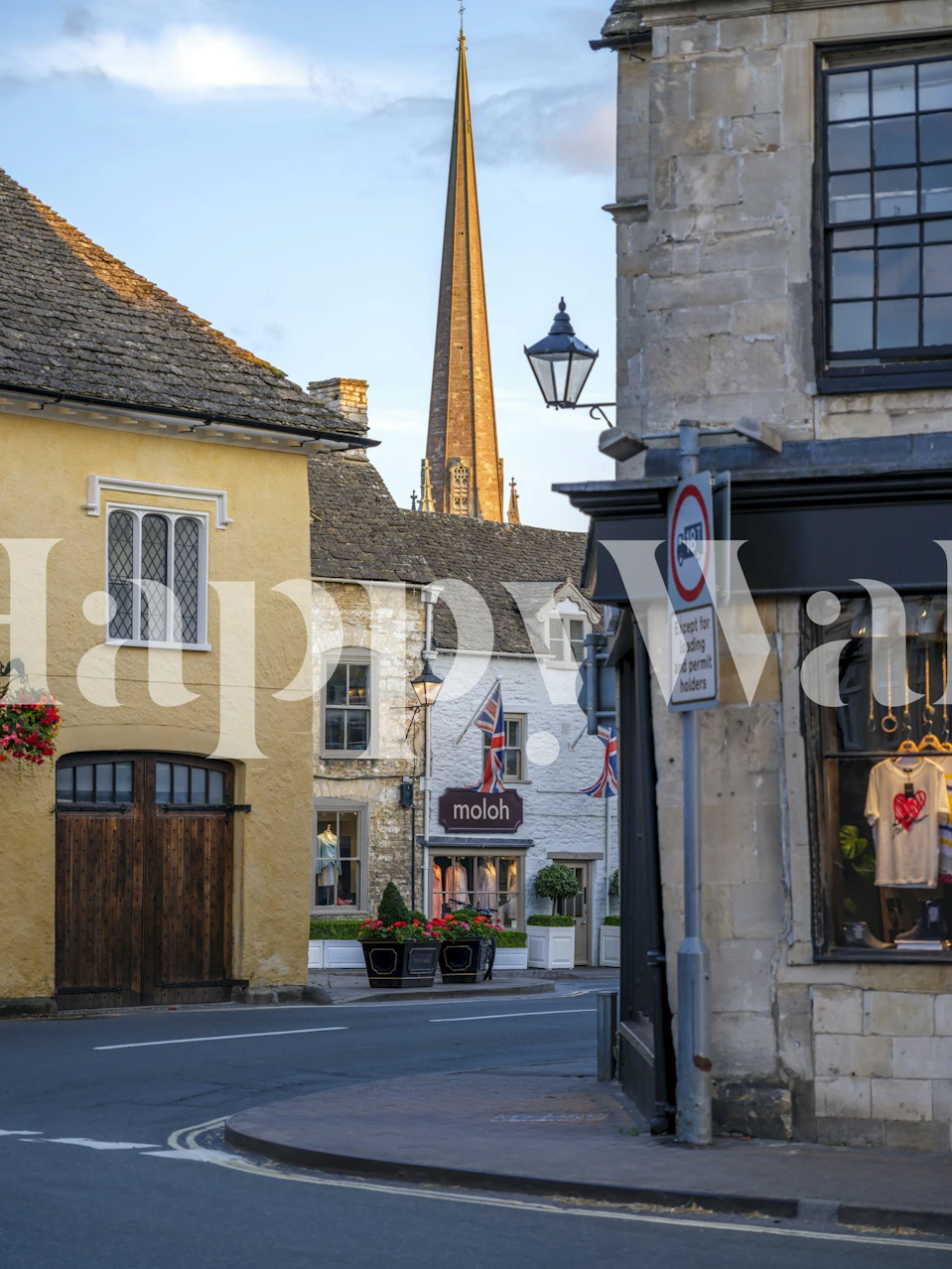 Charming English village street scene with yellow buildings and a church spire wallpaper