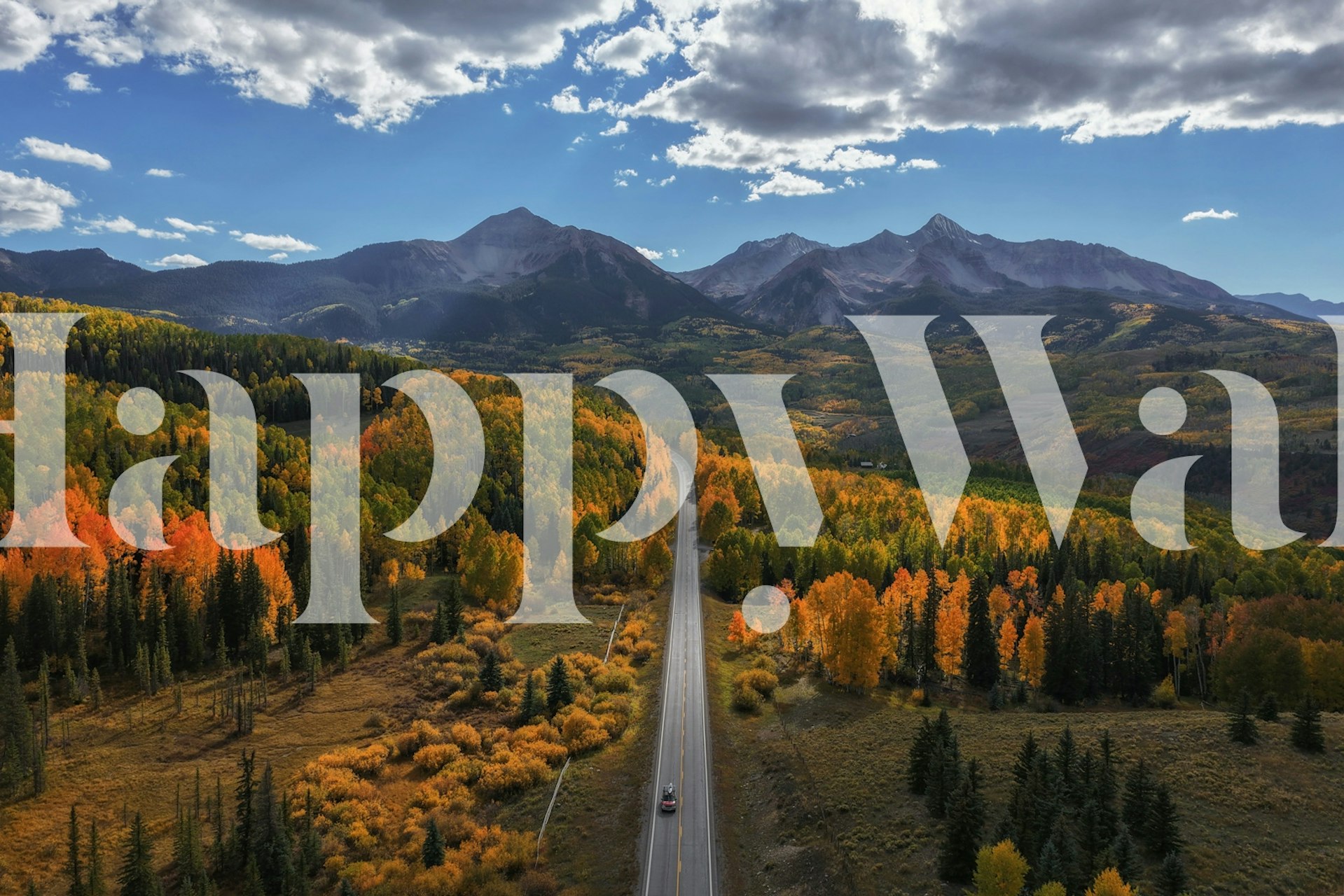 Scenic autumn landscape with vibrant orange trees and mountains wallpaper