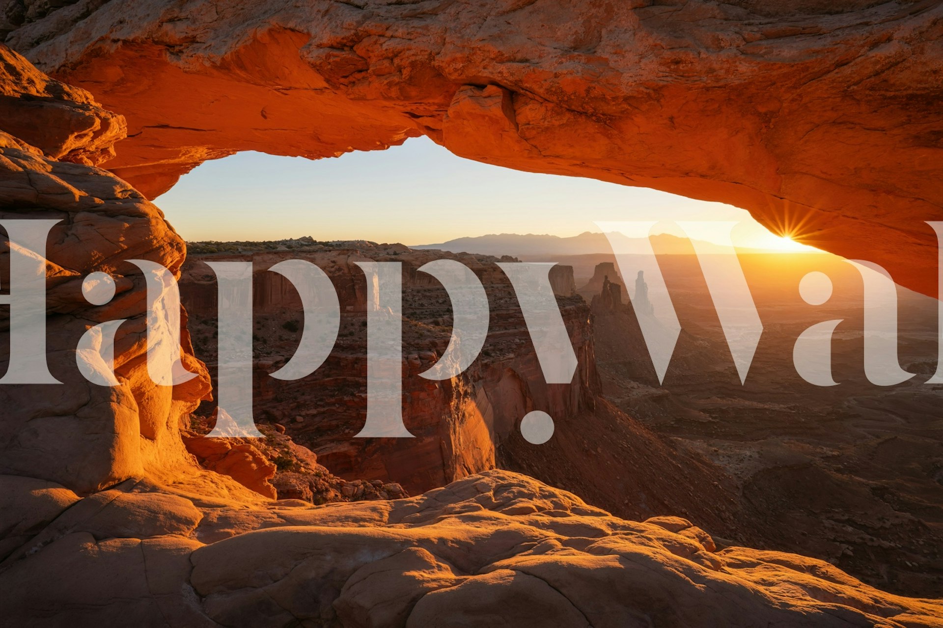 Mesa arch with sunrise over rocky landscape wallpaper