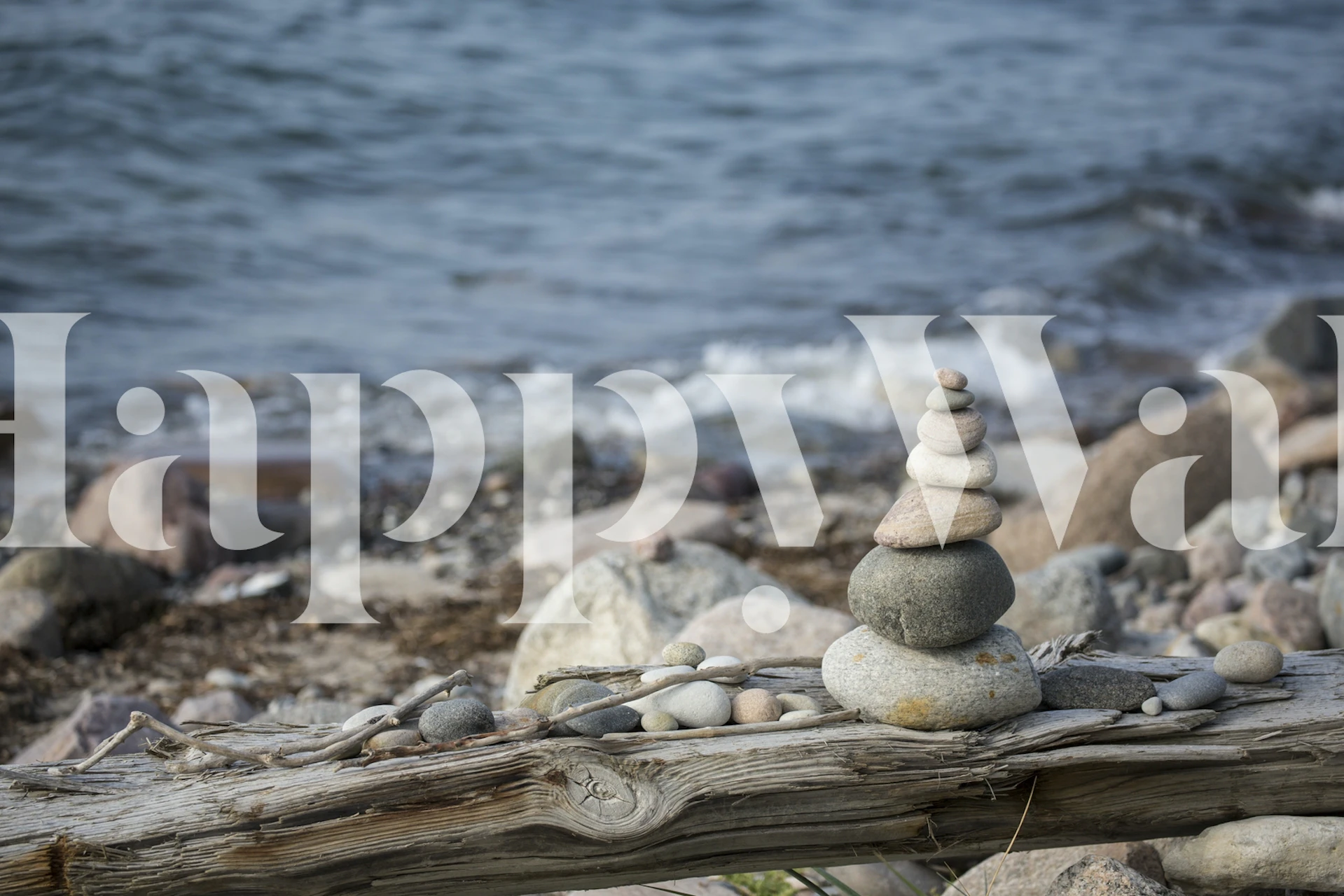 Stacked pebbles near the water's edge on a driftwood log wallpaper