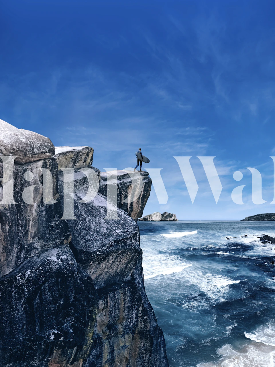 Surf waves crashing against a mountain cliff with a clear blue sky wall mural
