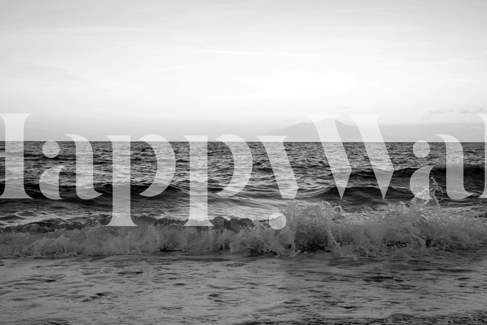 Black and white ocean waves with distant mountains wallpaper