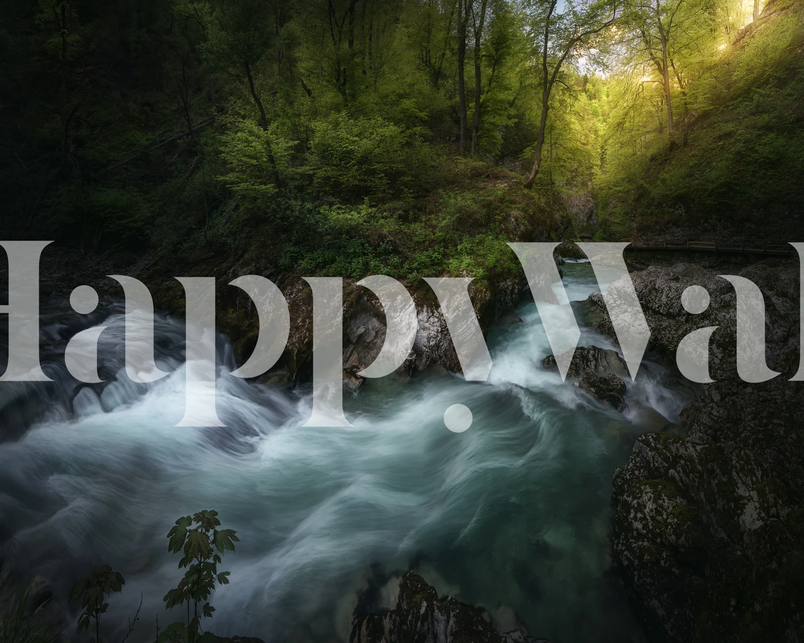 Lush green river flowing through rocks and trees wallpaper