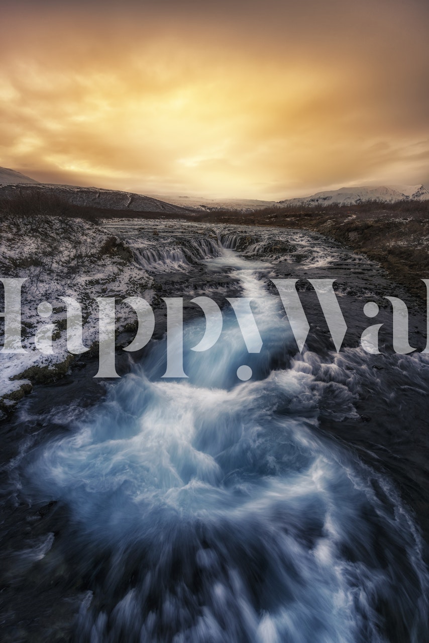 Brilliant sunset over the Bruarfoss waterfall with dynamic blue waters flowing through rugged landscape