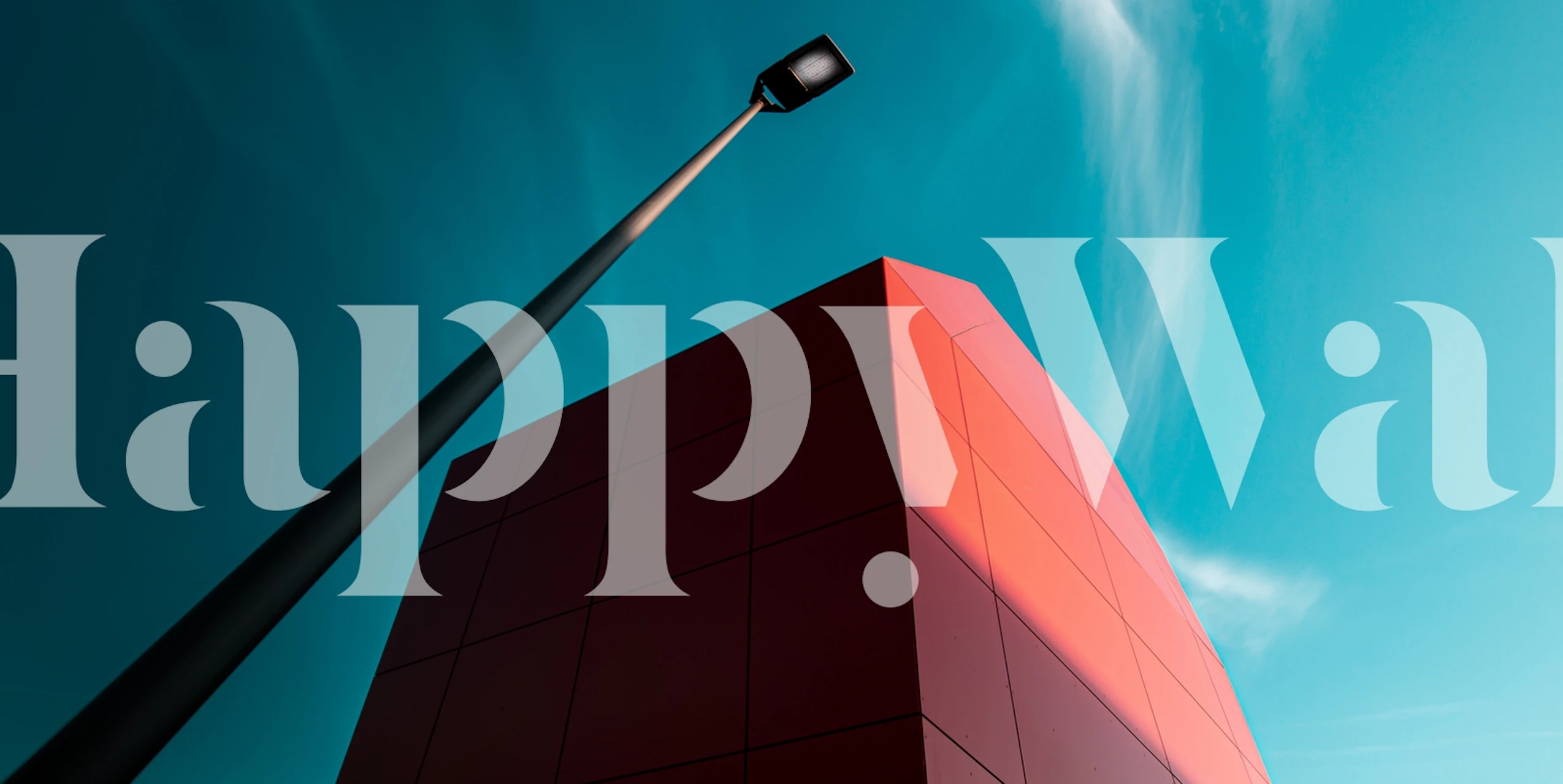 Apstraktni crveni geometrijski zidni mural pod plavim nebom