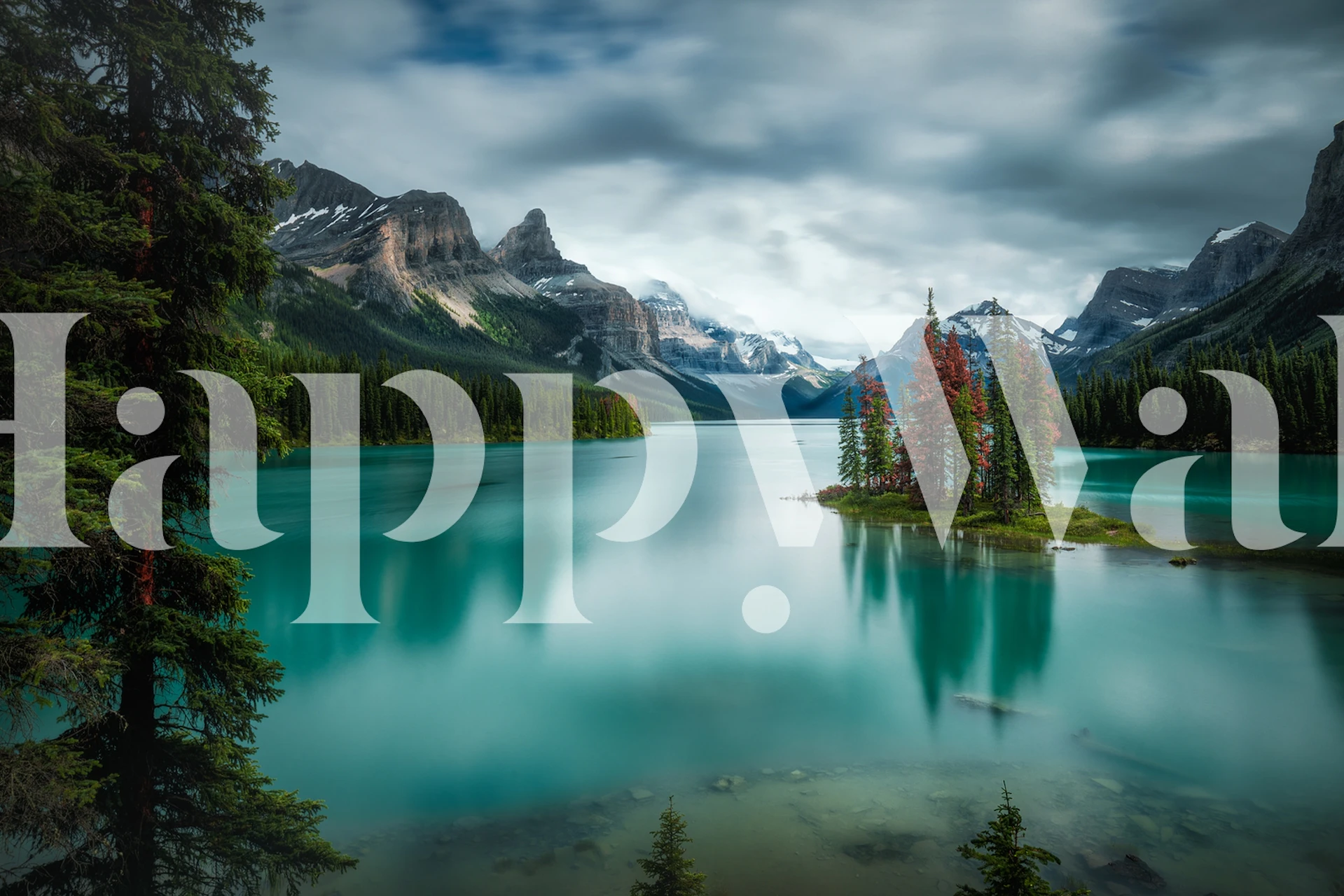 Mountain lake with lush green trees and rocky mountains wallpaper