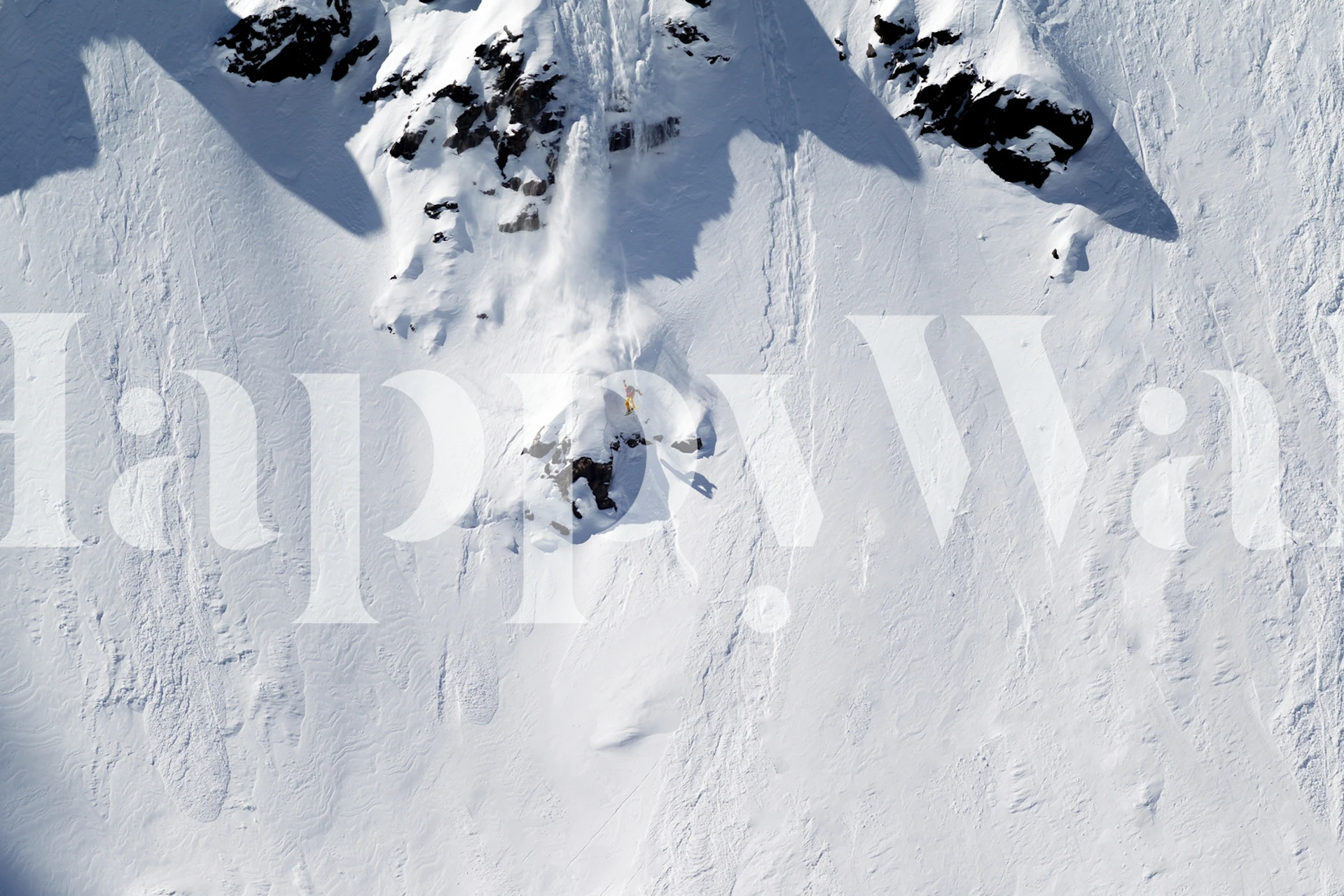 Snowy mountain landscape with rocky peaks and smooth snow wallpaper
