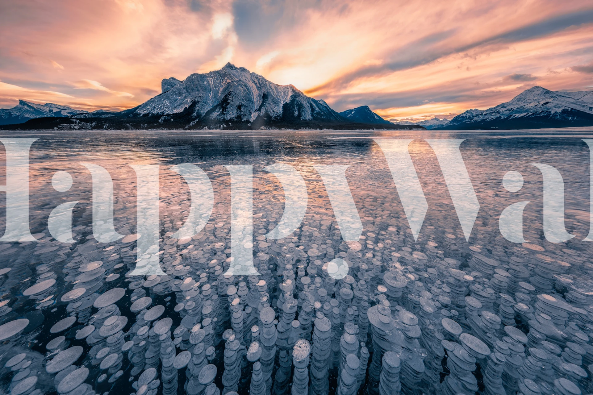 A tranquil sunrise over a frozen bubble lake with mountain backdrop wall mural