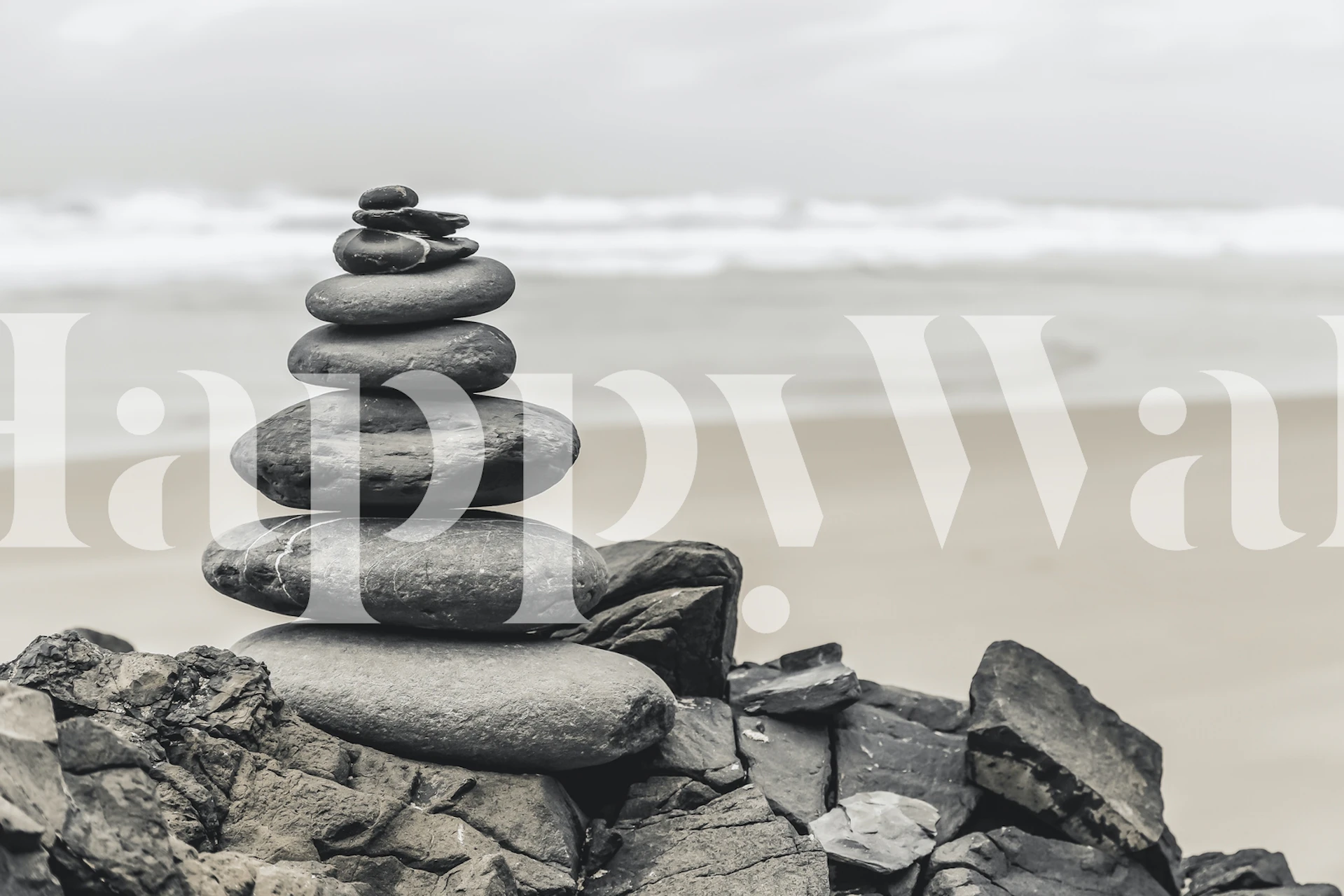 Stone cairn balanced on a tranquil Algarve beach under a misty sky wall mural