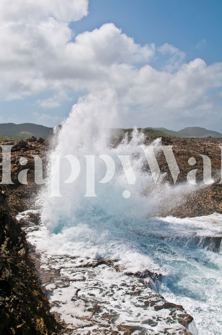 Ocean waves crashing against rocks with splashes of blue and white wallpaper