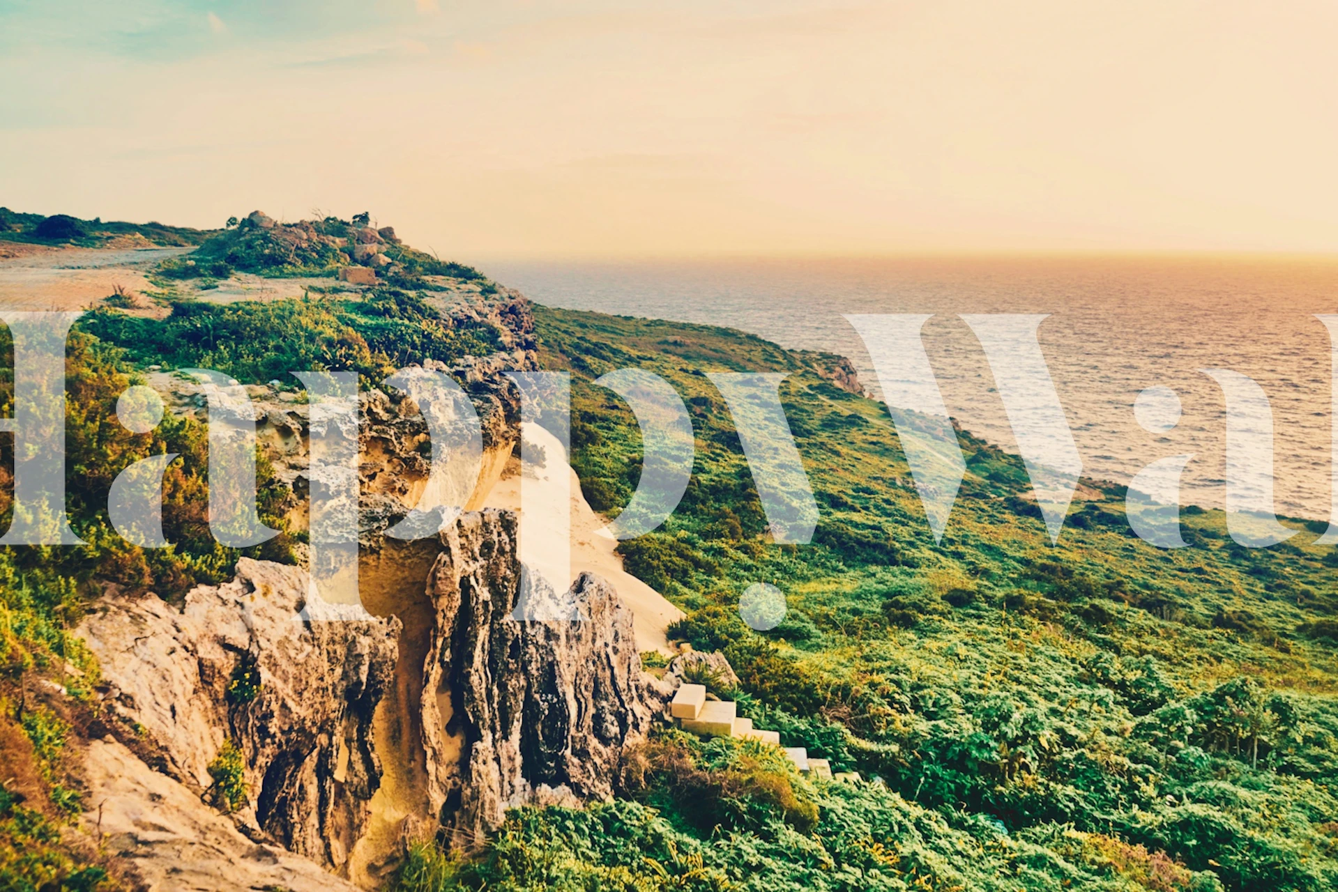 Ocean Sunset wall mural depicting the sun setting over a coastal landscape with cliffs and lush greenery