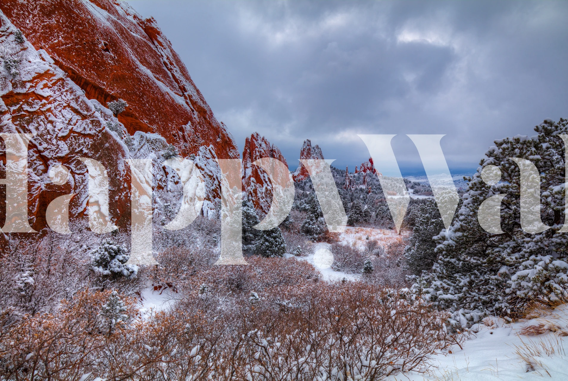 Snow-covered red rock landscape with trees and gray sky wallpaper