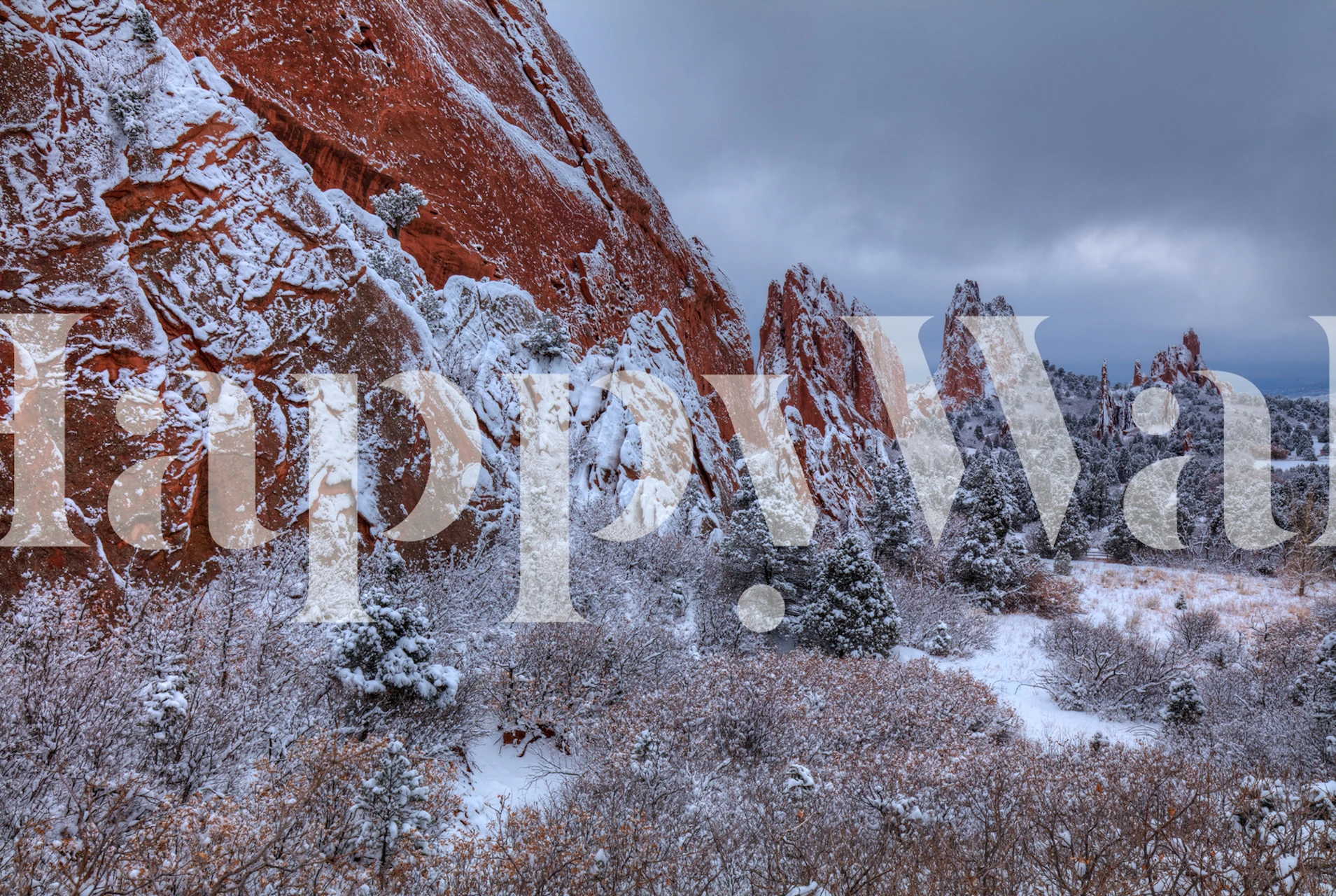 Snow-covered cliffs and rocks with traces of red and orange hues, depicting seasonal changes in nature.