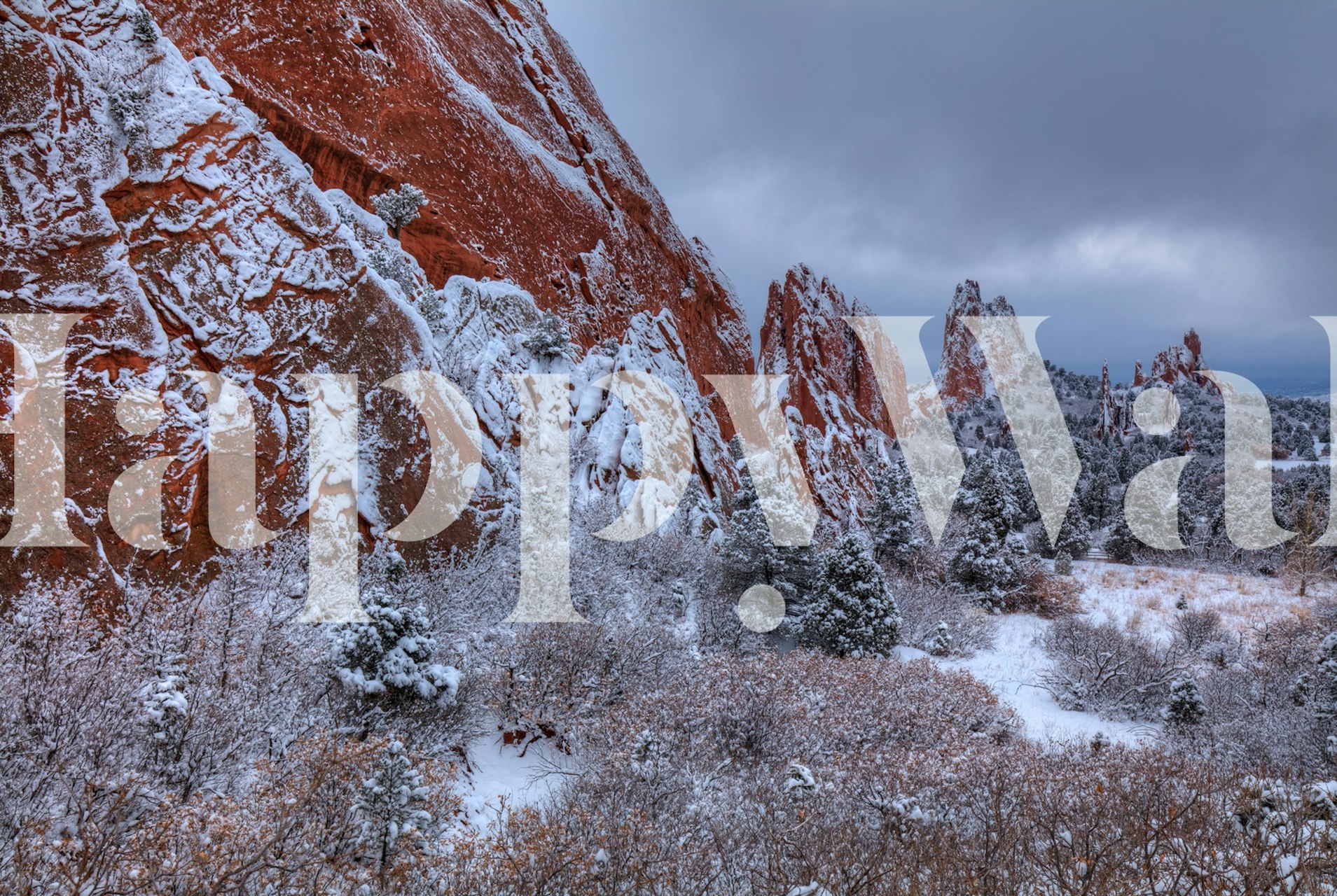 Snow-covered cliffs and rocks with traces of red and orange hues, depicting seasonal changes in nature.