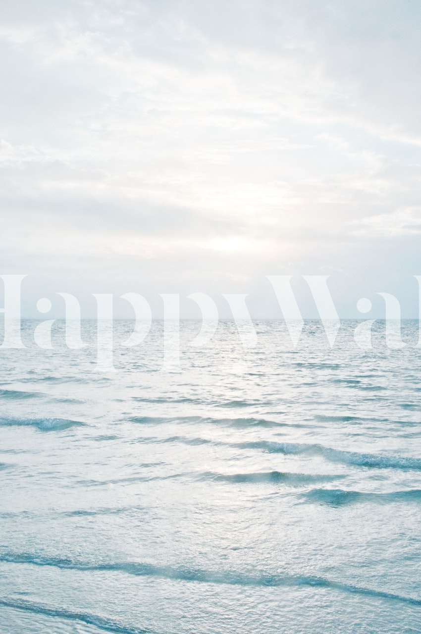 Calm ocean waves at sunrise with soft blue tones wallpaper