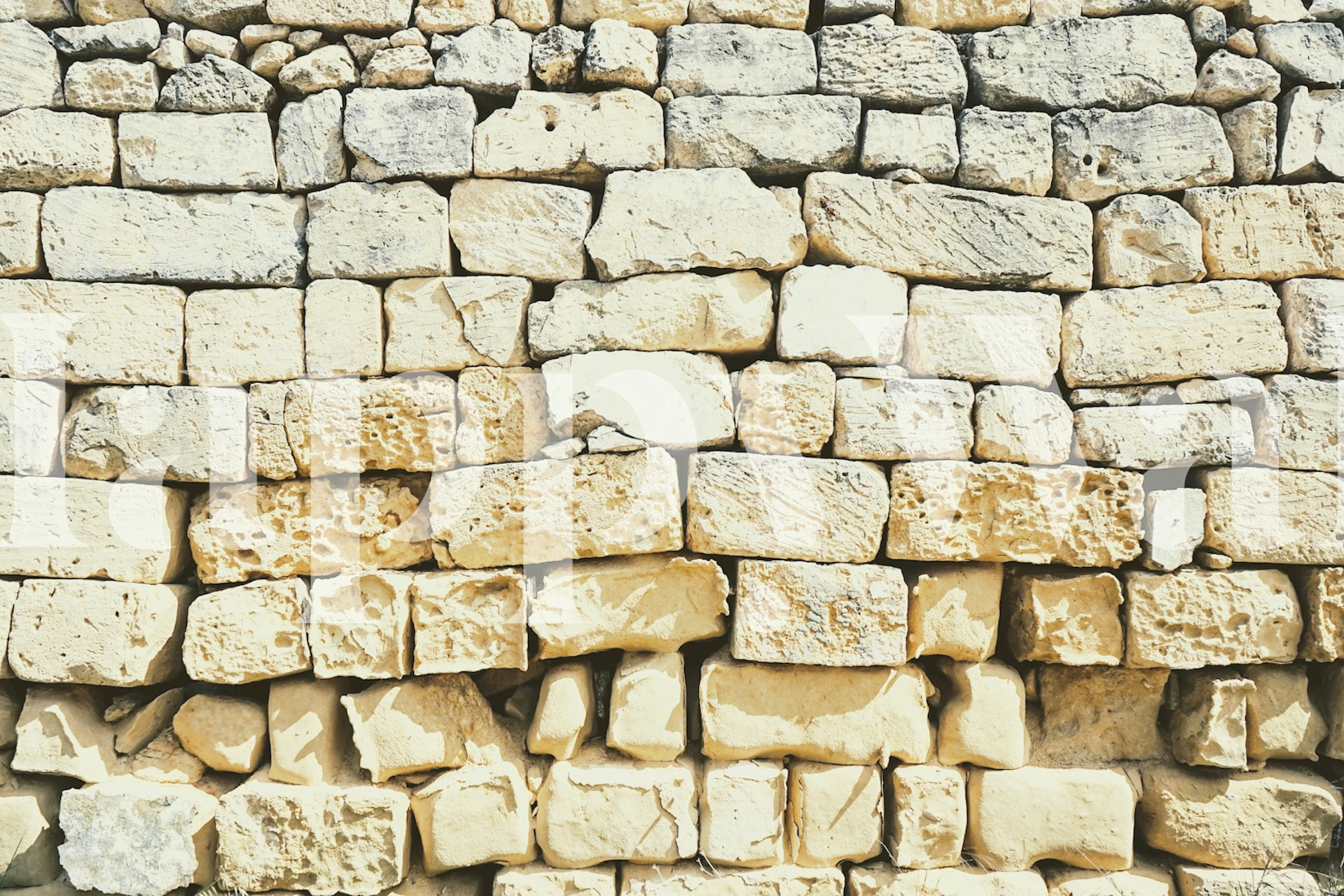 Worn sandstone wall in beige and tan colors, textured wallpaper