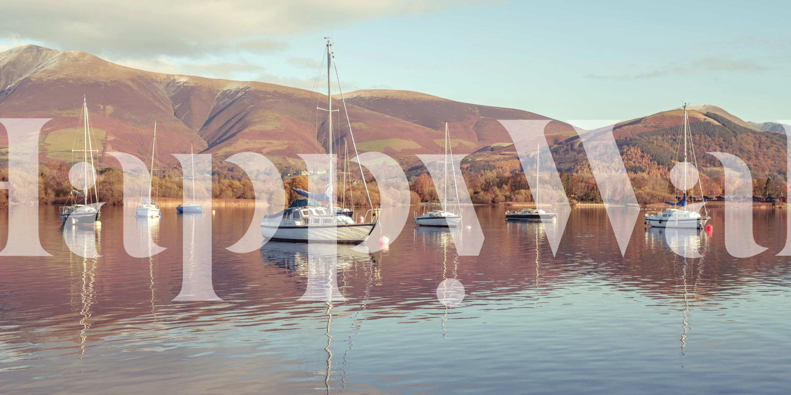 Sail boats on a lake with mountains in background