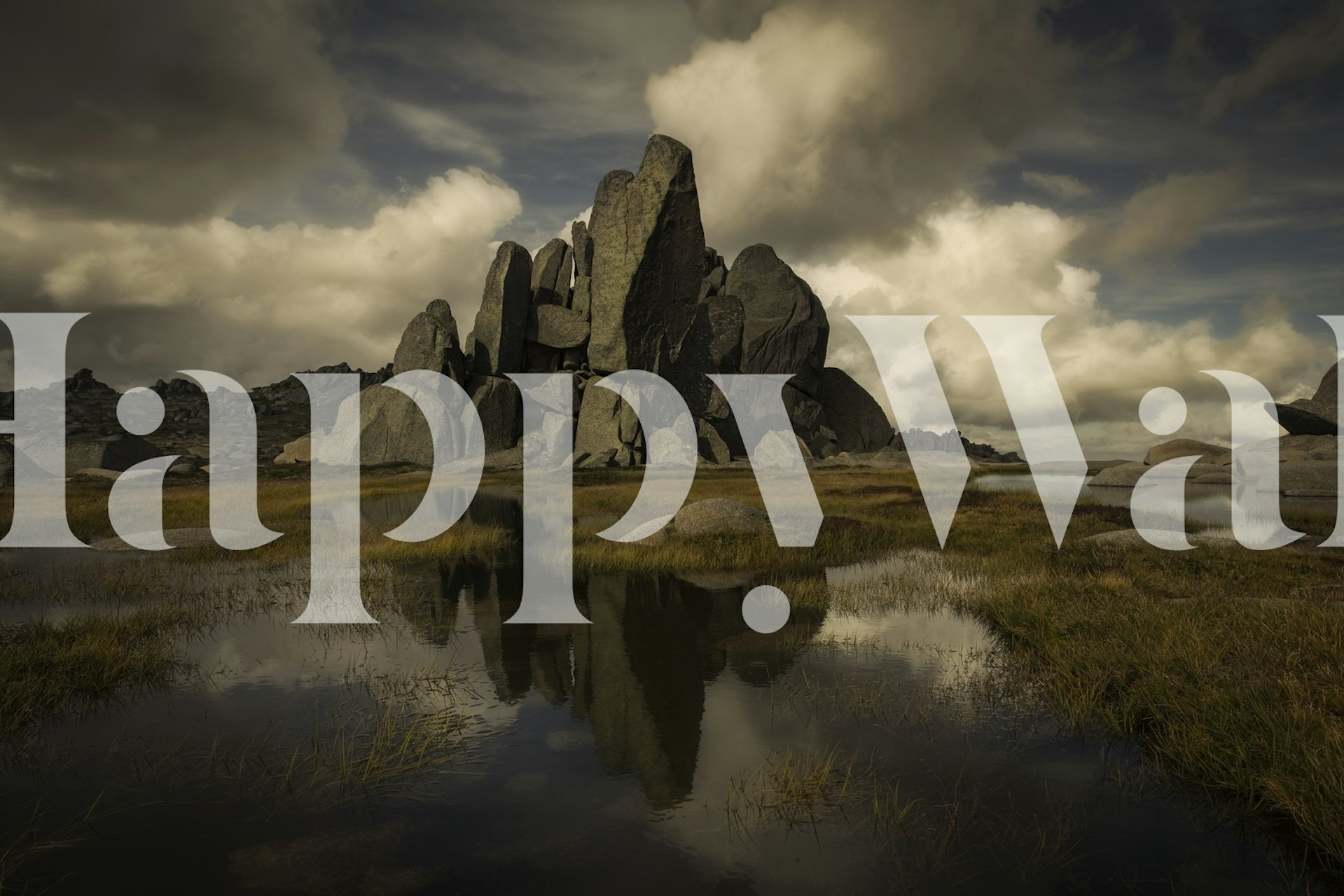 Rocky landscape with cloudy sky and water reflection wallpaper