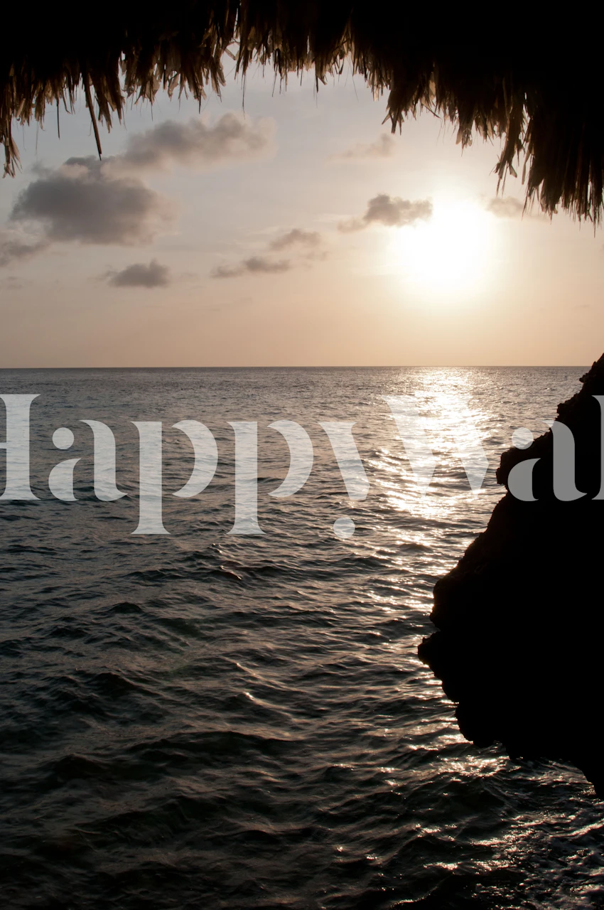 Vivido tramonto sull'oceano con la sagoma di una costa rocciosa e un tetto di paglia sul lato