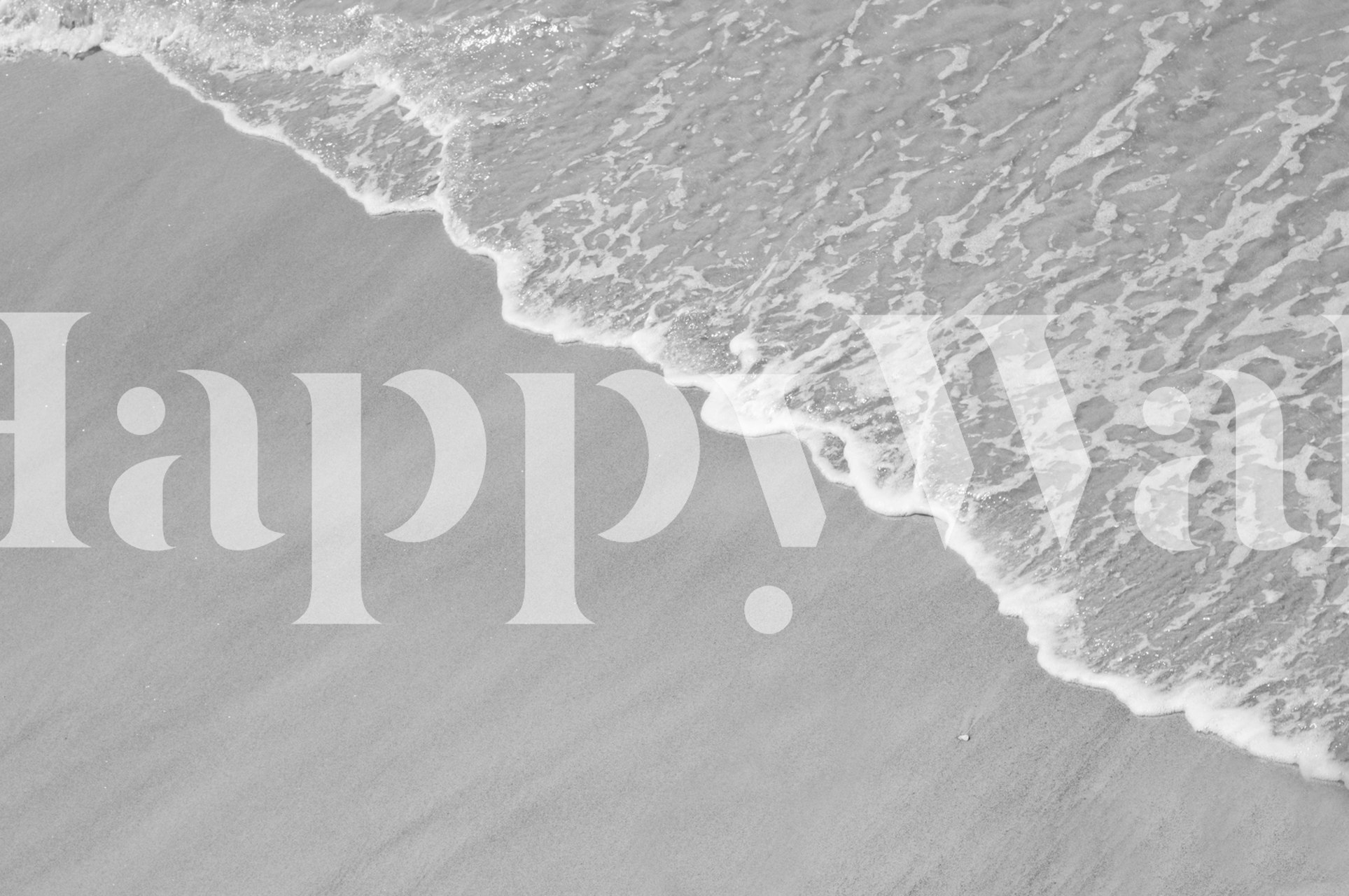 A grayscale image of a serene beach with soft sea foam lapping onto the sandy shore.