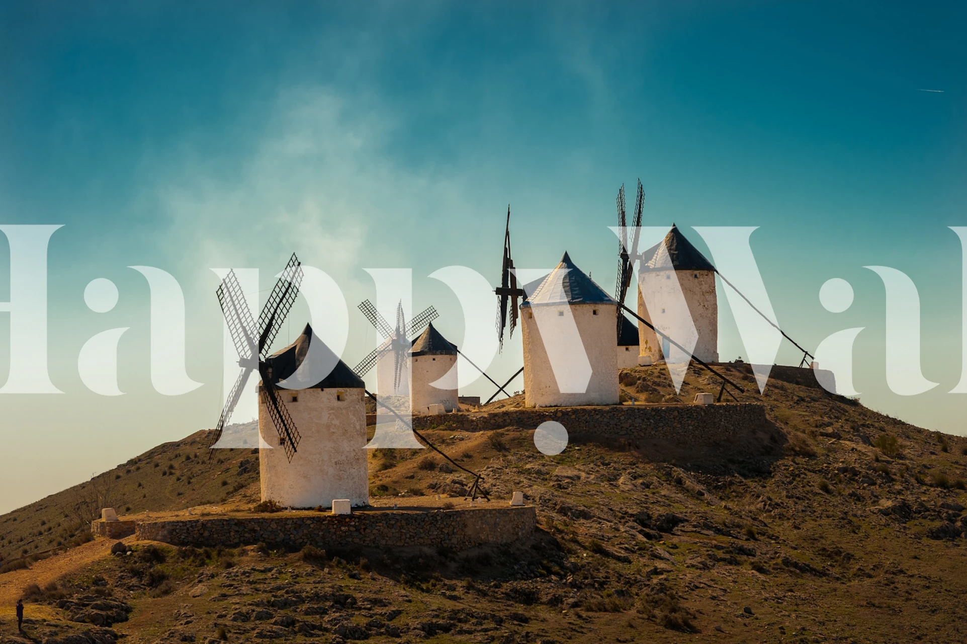 Five white windmills on a hill with a blue sky wallpaper