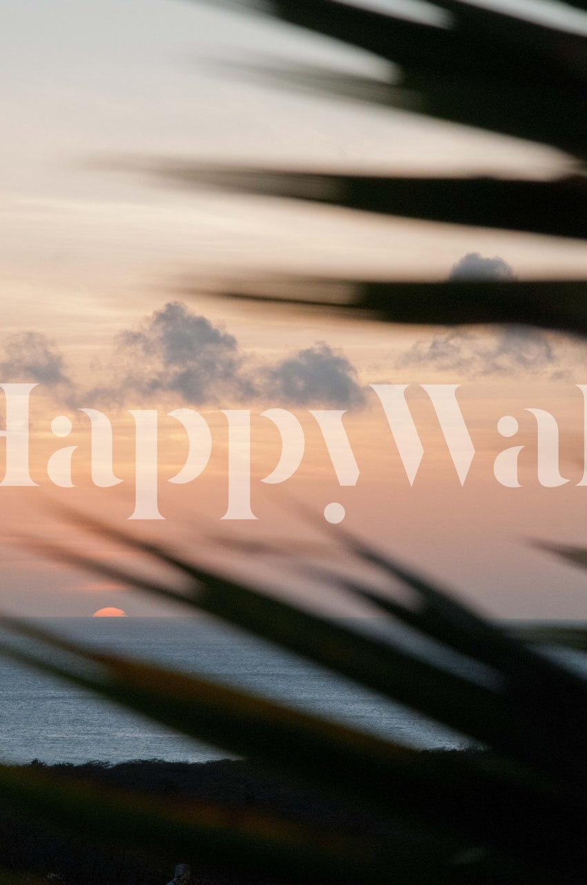 Tropical sunset with silhouetted palm leaves in warm colors wallpaper