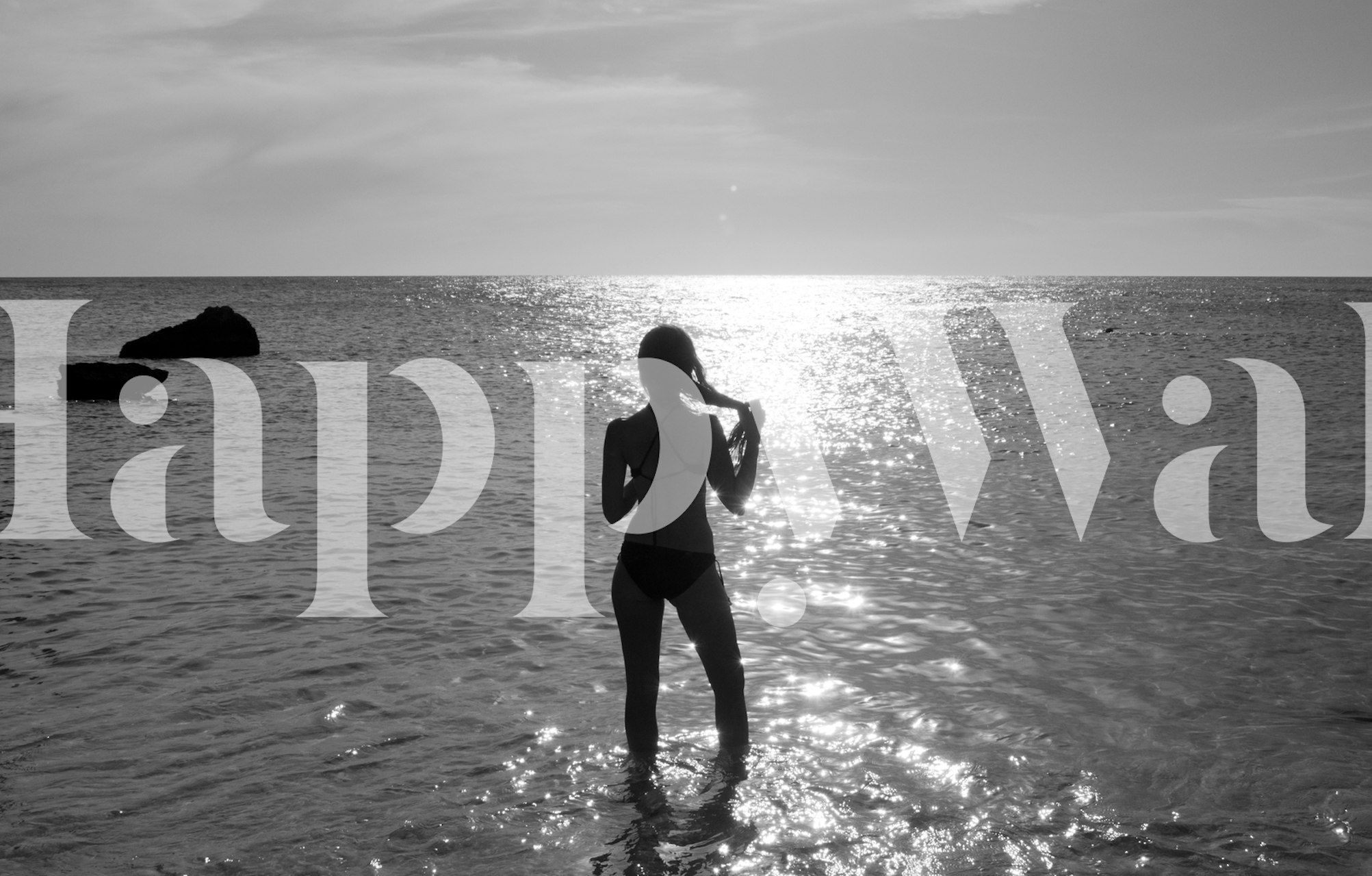 Silhouette of a person in shallow water against a black and white sunset wallpaper