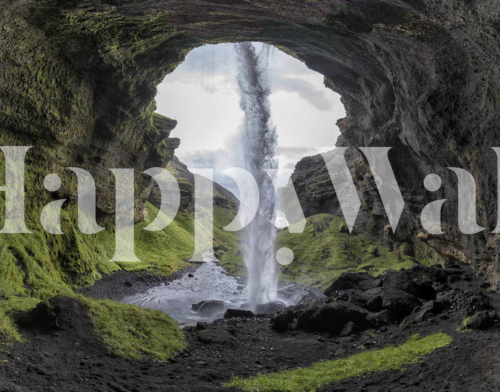 Waterfall cascading through rocks surrounded by green grass wallpaper