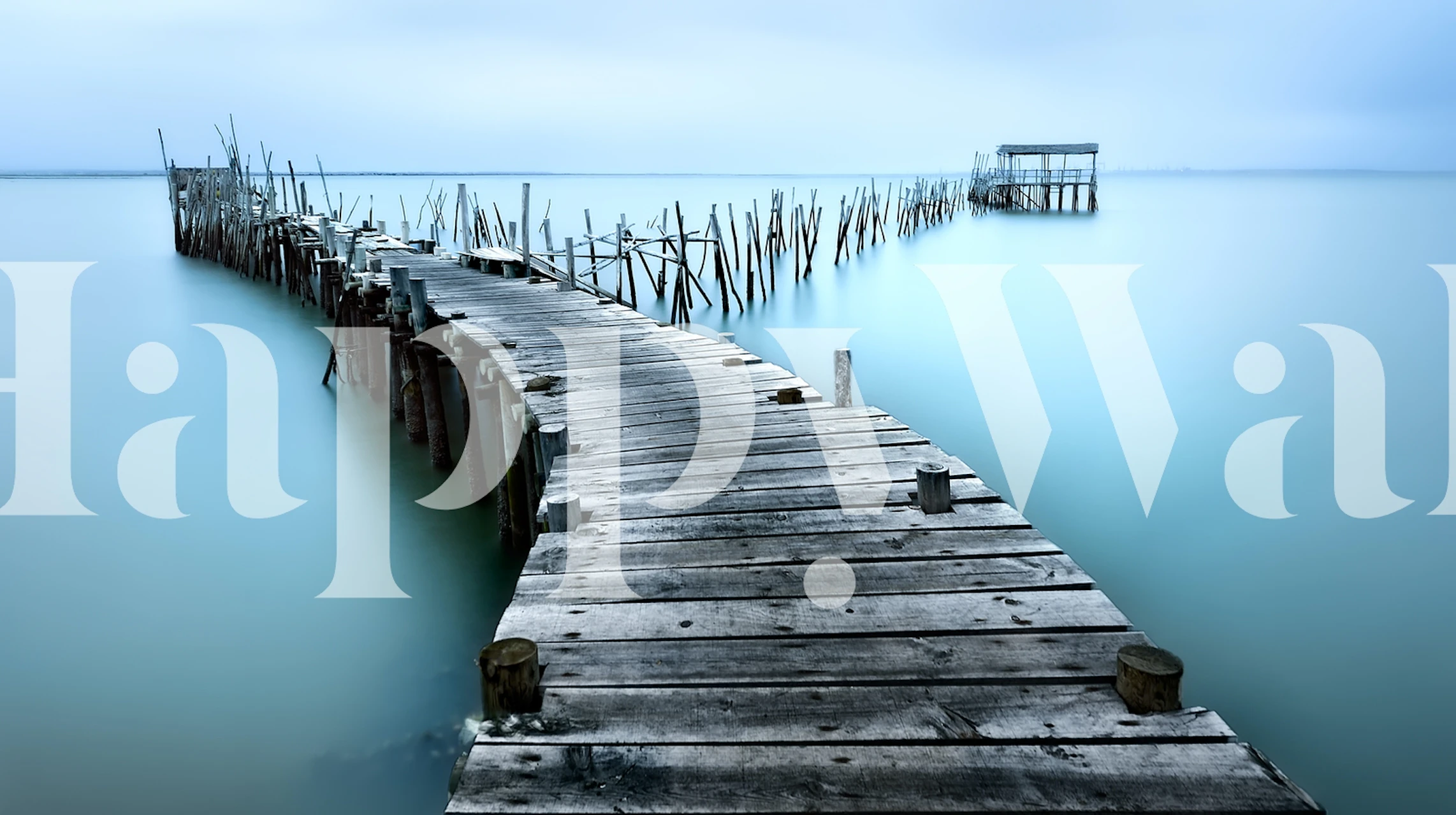 Wooden planks extending over calm blue water wallpaper